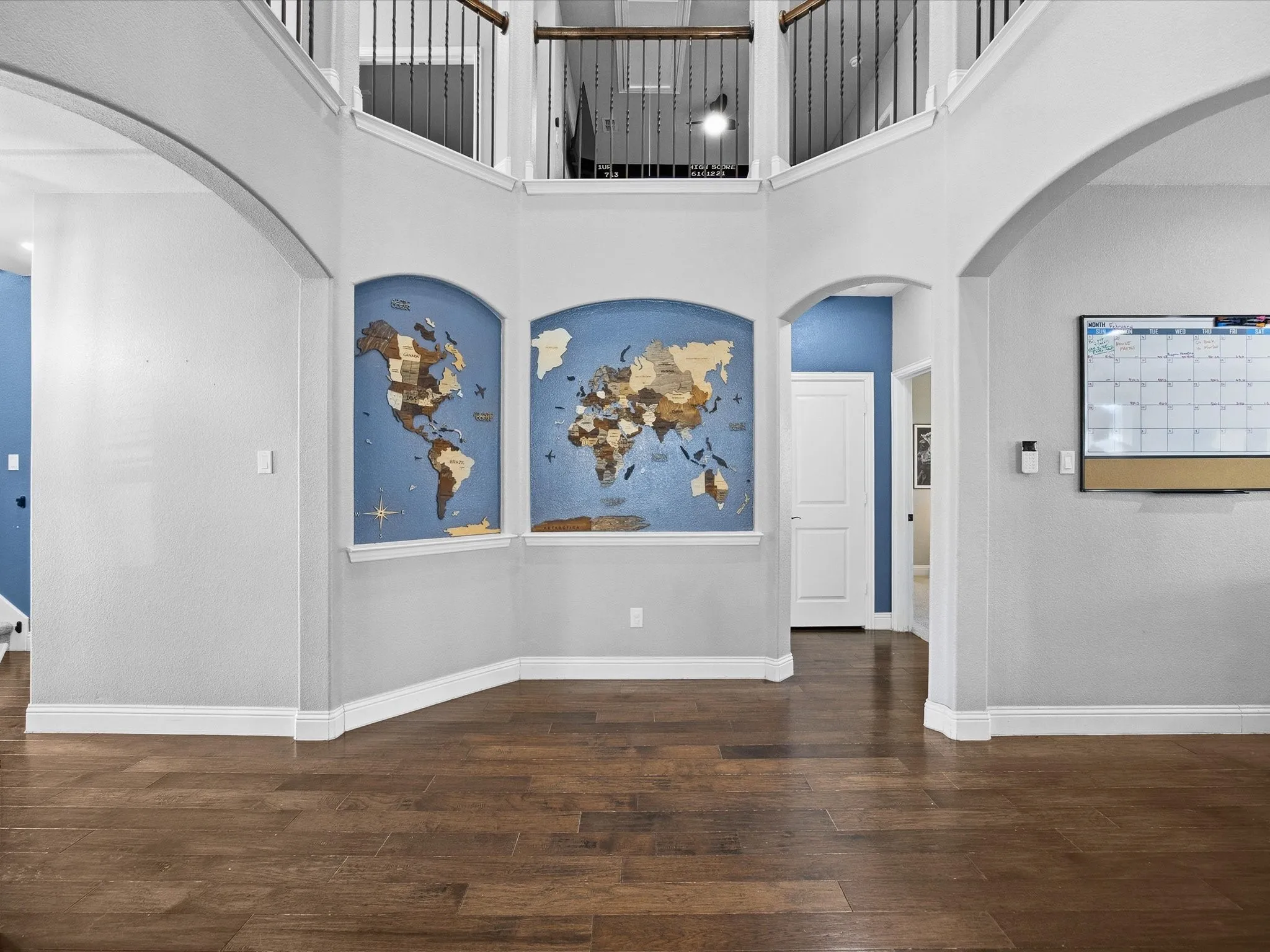 Entrance foyer with arched walkways, a high ceiling, and dark wood finished floors