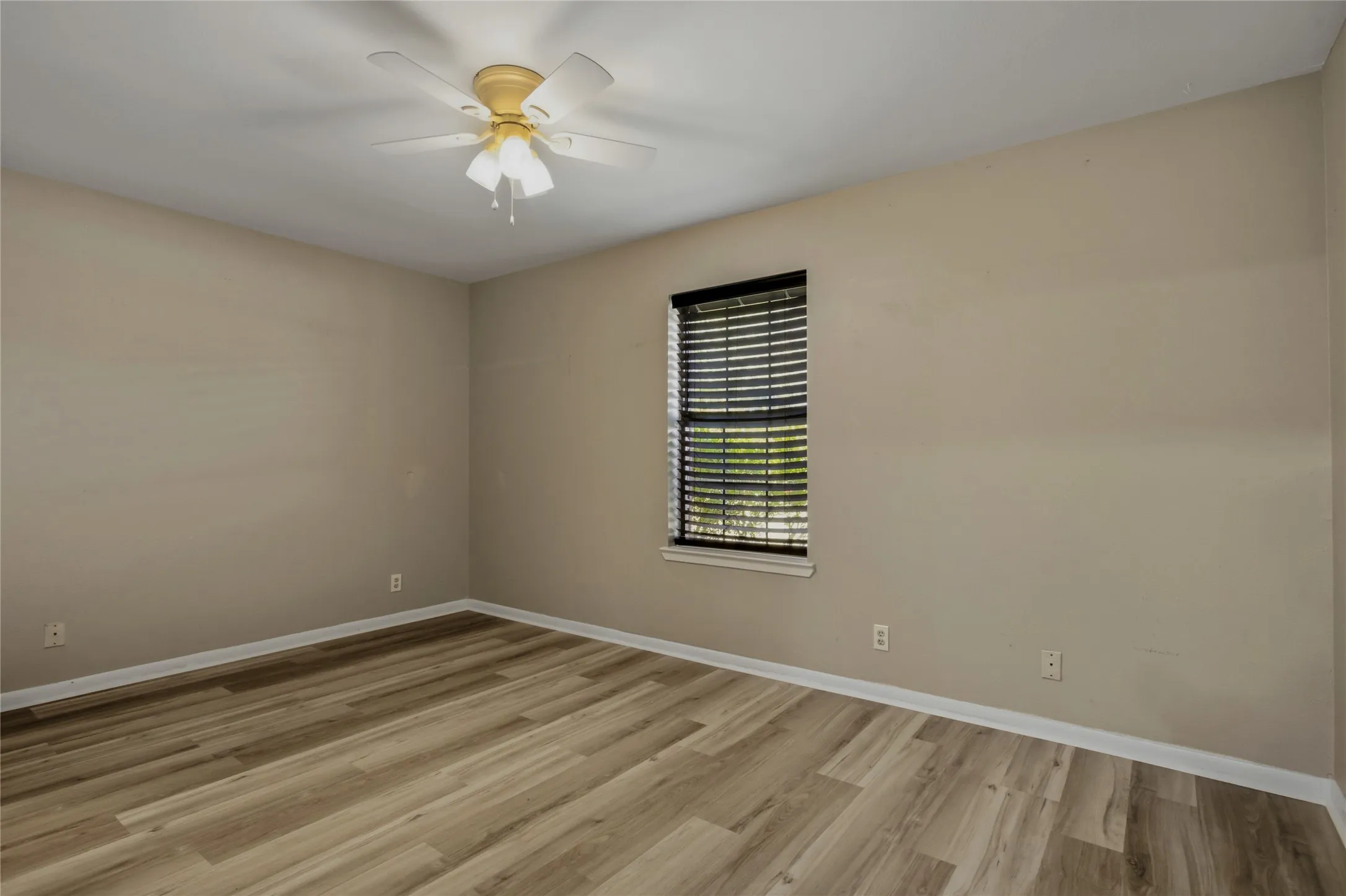 Wood-finish flooring with neutral wall tones and a ceiling fan
