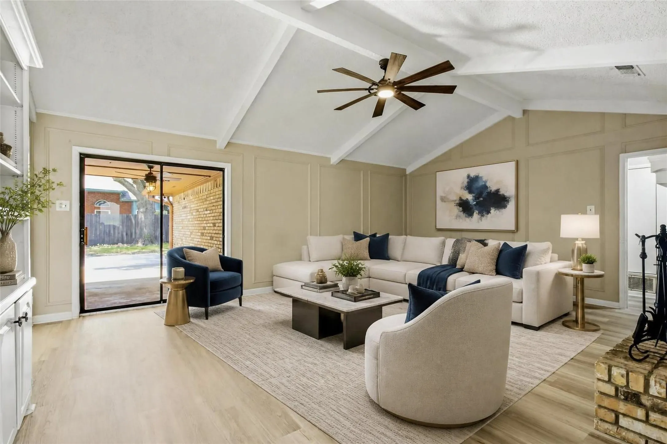 Virtual staged Vaulted ceiling with exposed beams, wood-finish flooring, built-in shelving, fireplace with brick surround, and sliding glass door to outdoor area