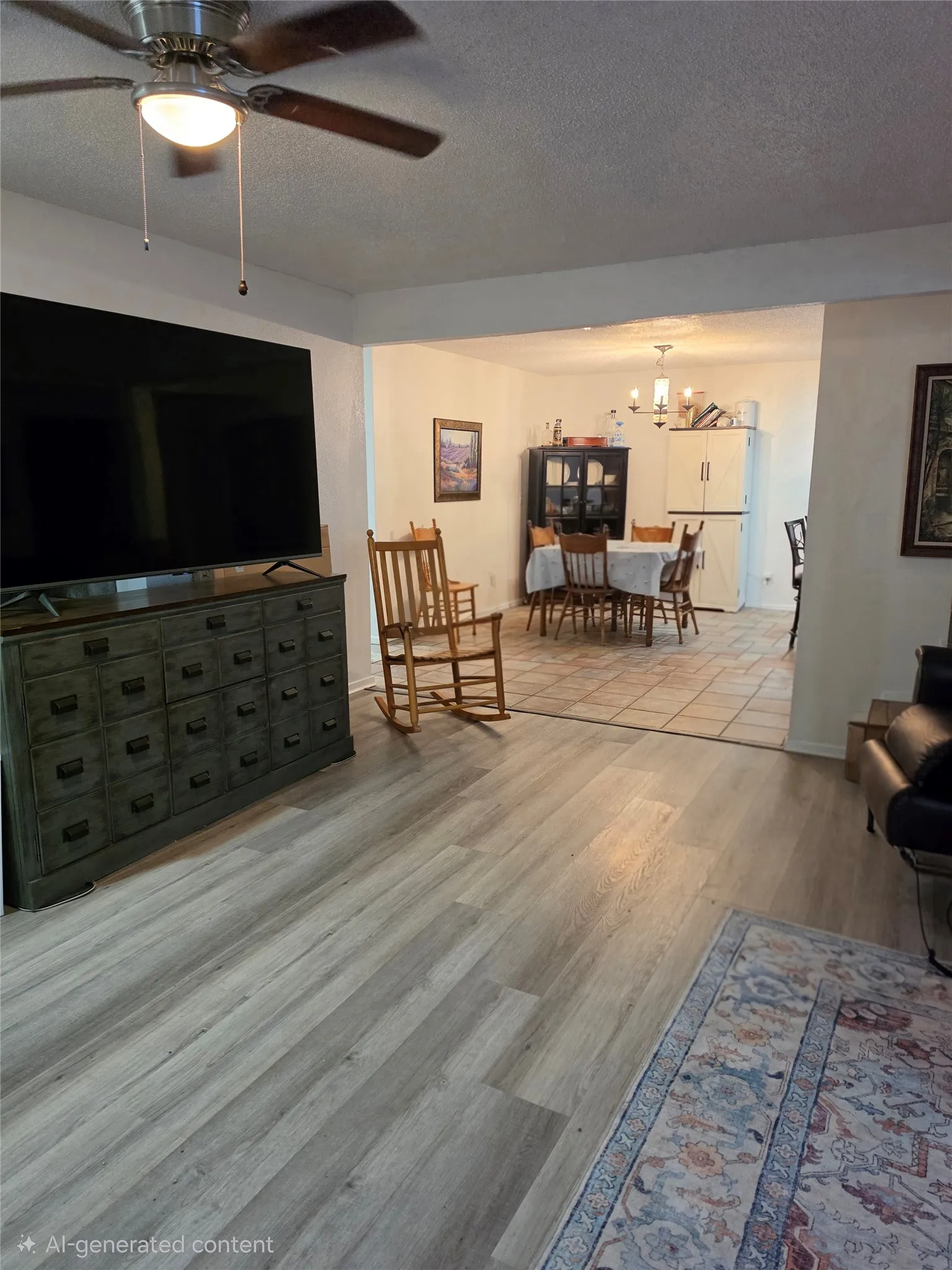 Spacious interior featuring wood-finish flooring, a ceiling fan with integrated lighting, and white walls