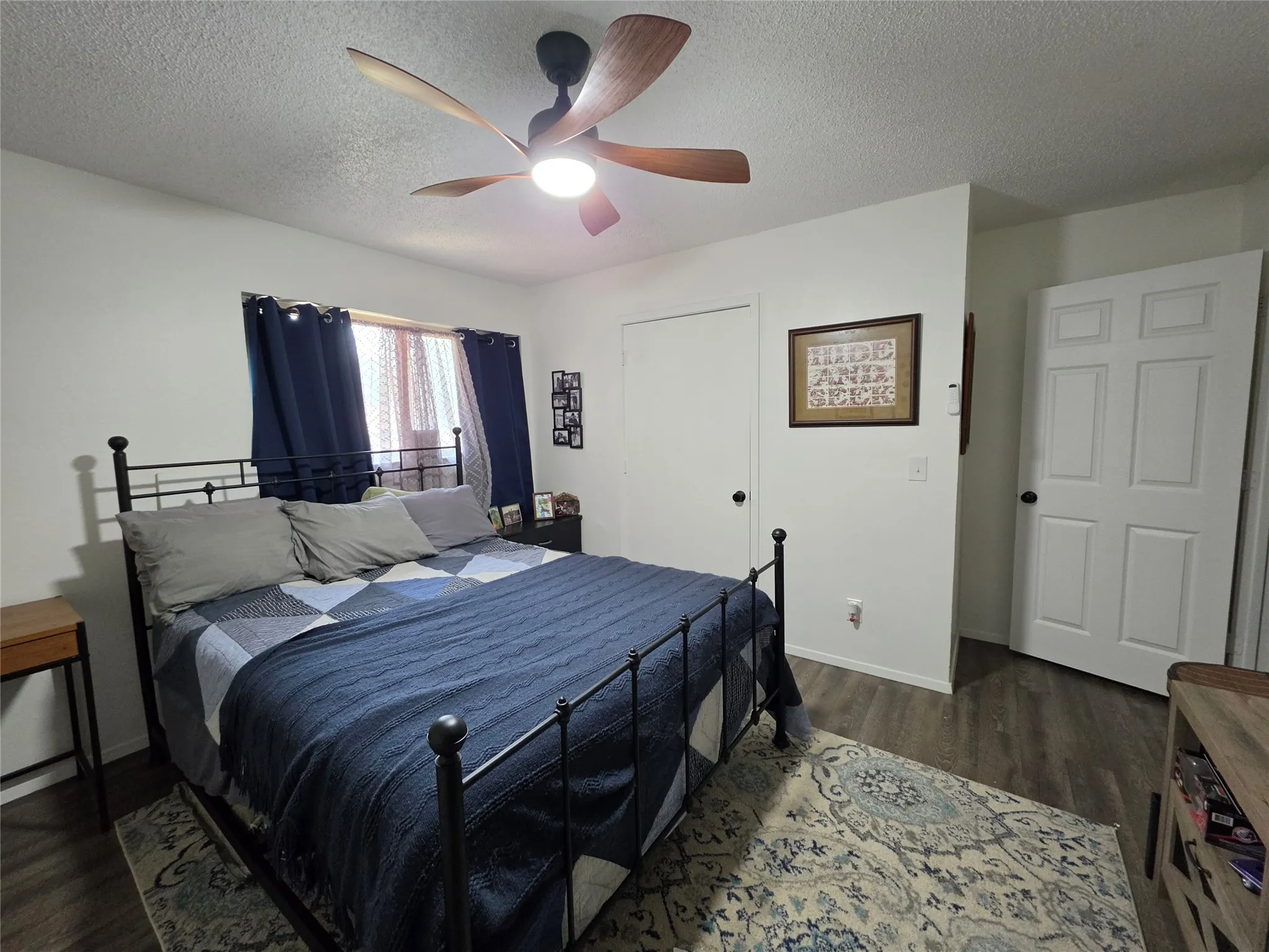 Bedroom featuring wood-finish flooring and a ceiling fan with integrated lighting