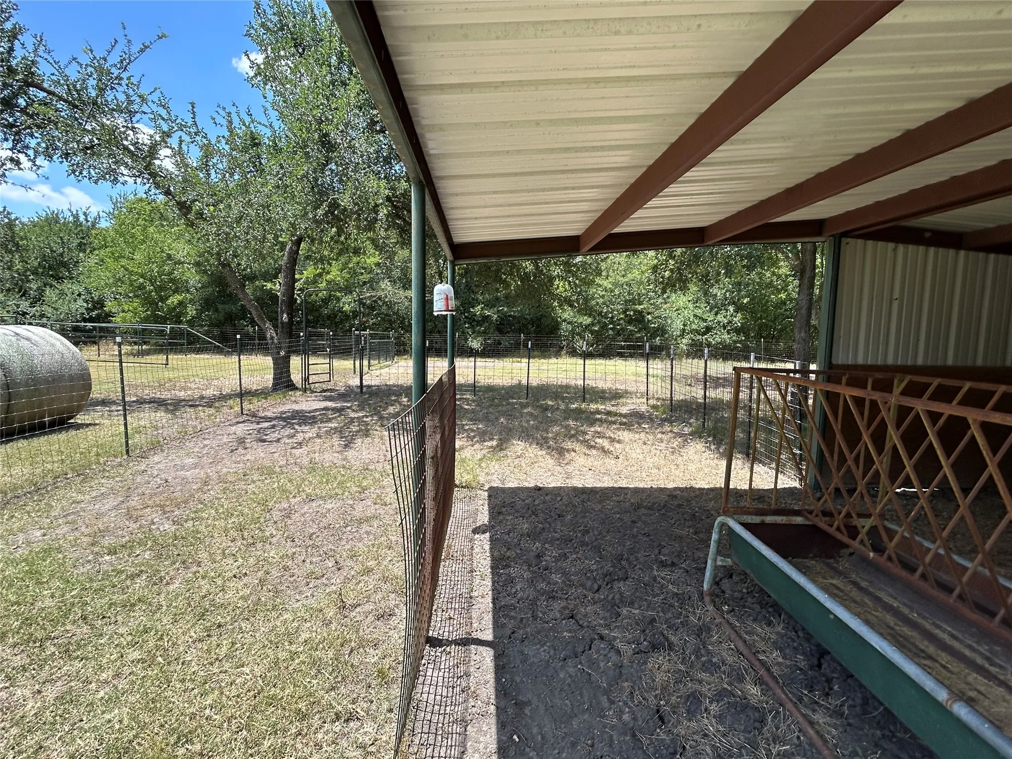Open-air shed structure with a metal roof and exposed beams