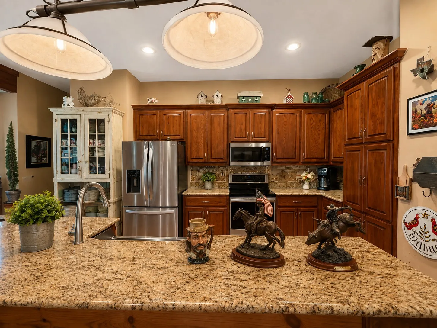 Expansive kitchen island with granite countertops, featuring a stainless steel sink and gooseneck faucet