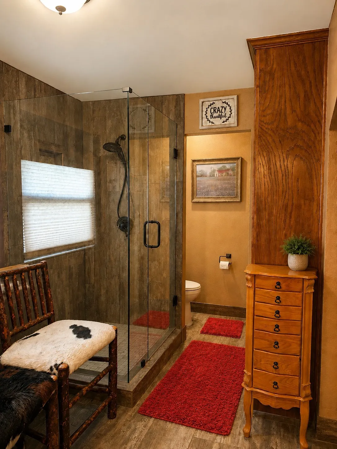 Glass-enclosed shower with dark fixtures and wood-finish wall panels, complemented by wood-finish flooring