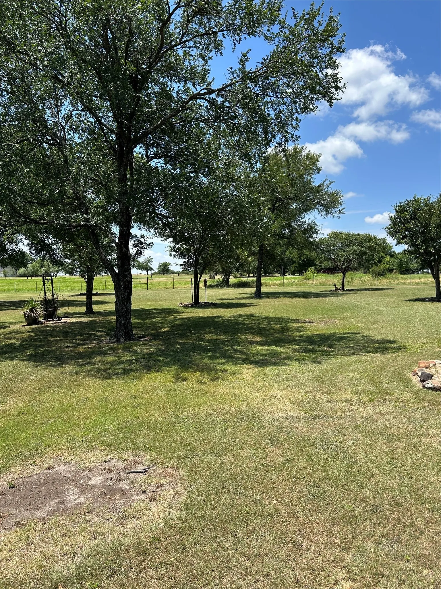 Expansive green lawn featuring mature trees
