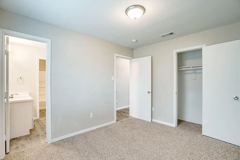 Carpeted room with light neutral wall tones and white trim