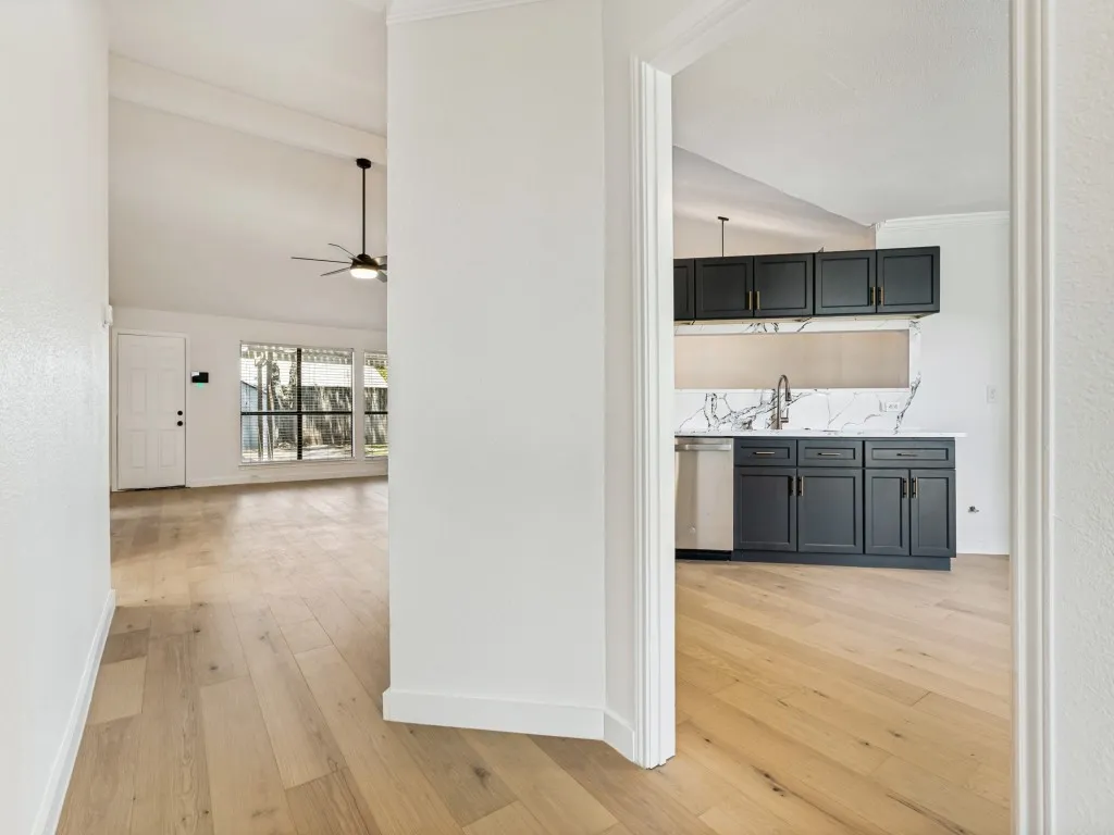 Modern kitchen cabinetry with gold-tone hardware, stainless steel sink, and a contrasting backsplash