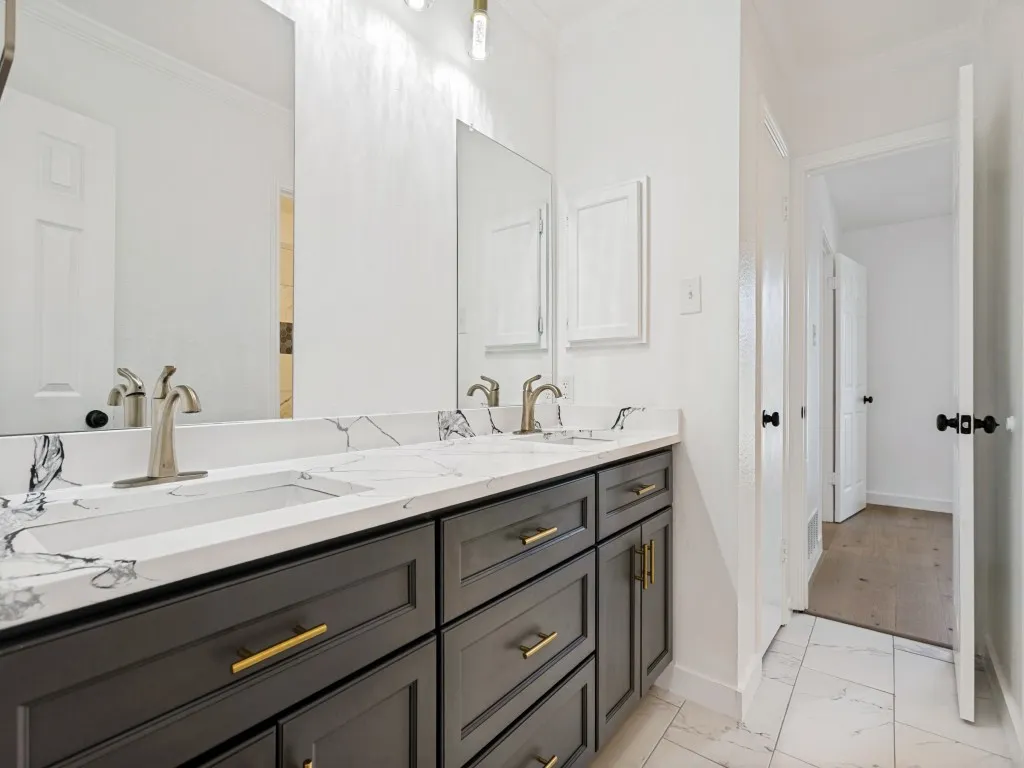 Dual vanity featuring a white countertop with grey veining, two integrated rectangular sinks, and brushed nickel faucets