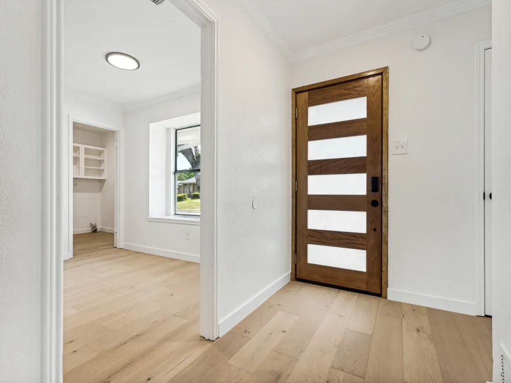 Modern wood-paneled entry door with frosted glass inserts