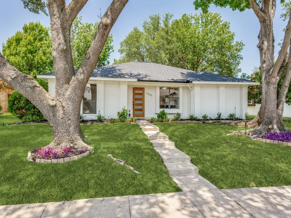 White painted brick exterior with a dark shingled roof
