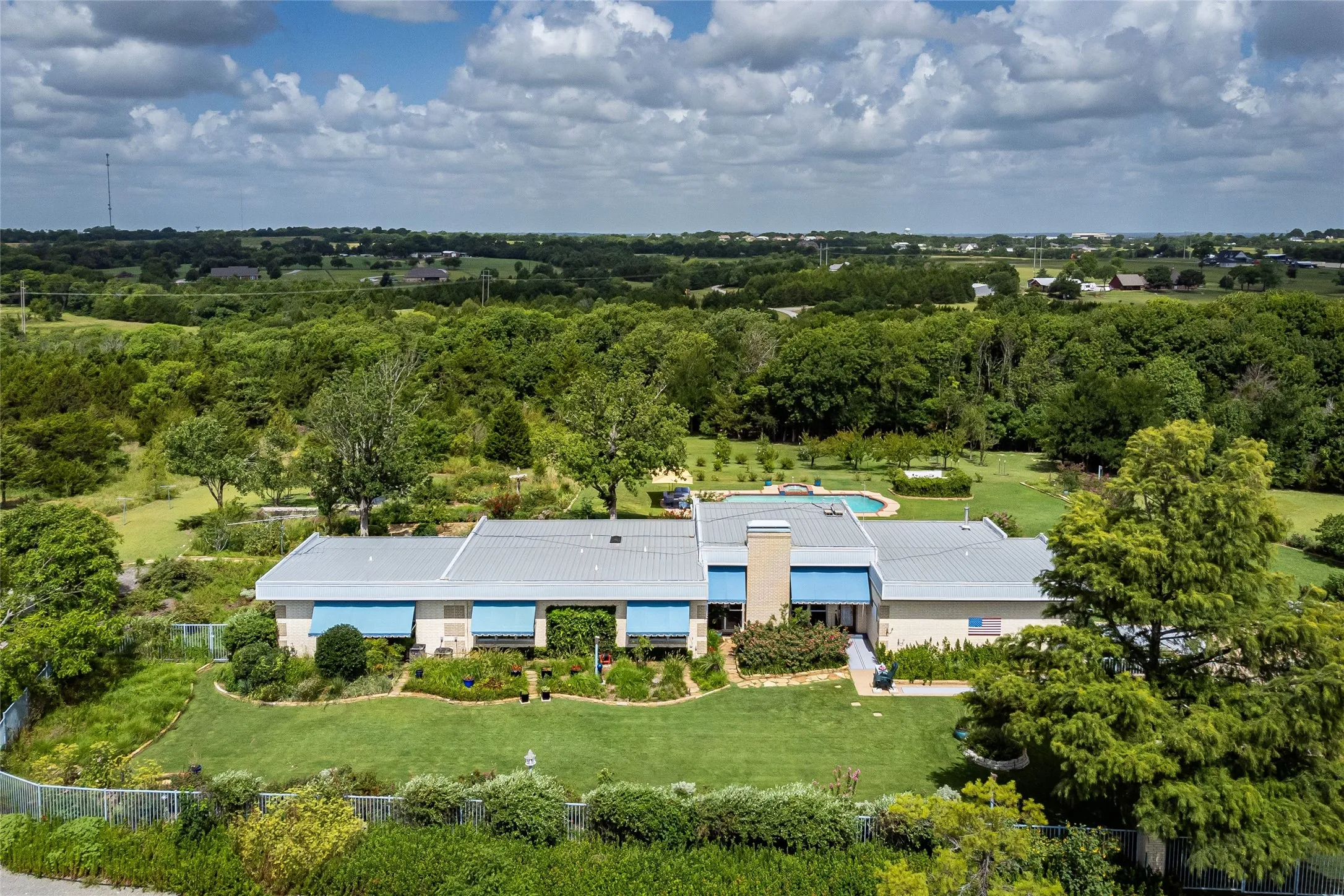 Aerial view of the main residence.  Due to limited permitted photo space not shown are the pumphouse, storm shelter which has French drains surround it, epoxy roof and freshly painted interior and floor. The estate has 3 septic tanks serviced.  A lightening rod is present on the main house and all garages. Dish network satellite dish is on the main house with wiring to all rooms. The Dish is also installed at guesthouse. There are 2 large 4-ton & 3 tone heat pumps, plus one electric 2-ton HVAC just for the large bonus room (gym).HVAC Carrier Heat Pump system 3-ton R410A installed in main house bedroom area 2025, maintained, repaired on contract every April of each year since 1988:  Filters 16-20-4.”
•      HVAC Carrier Heat Pump system  4-ton R410A installed in main house living room/kitchen/office area in 2023, maintained, repaired on contract every April of each year since 1988:  filters 20-20-4.”
•      HVAC Carrier Heat Pump system 2-ton R410A installed in main house gym area