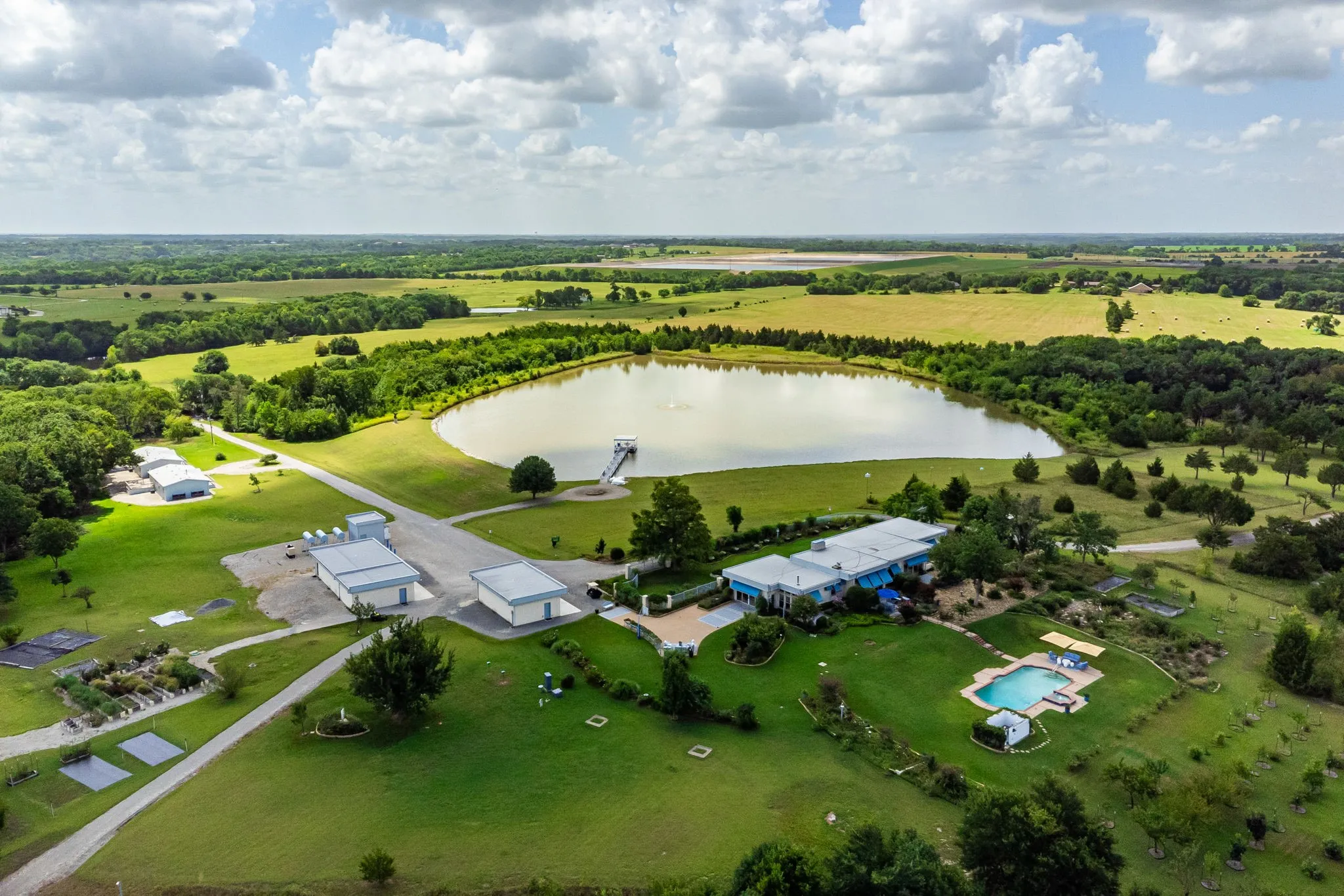 Aerial view reflects a portion of the estate showing the main house, two structure with a total 8-car garages spaces, 2 guest houses, main house, pool, stunning 10-acre lake, many trees, & manicured grounds. HVAC Carrier Heat Pump system 3-ton R410A installed in main house bedroom area 2025, maintained, repaired on contract every April of each year since 1988:  Filters 16-20-4.”
•      HVAC Carrier Heat Pump system  4-ton R410A installed in main house living room/kitchen/office area in 2023, maintained, repaired on contract every April of each year since 1988:  filters 20-20-4.”
• HVAC Carrier Heat Pump system 2-ton R410A installed in main house gym area year 2016, maintained & repaired each April:  Filters 14-20-4.”
• HVAC electric system in 2 guesthouses installed and repaired and maintained every April each year since constructed on site in 1997.