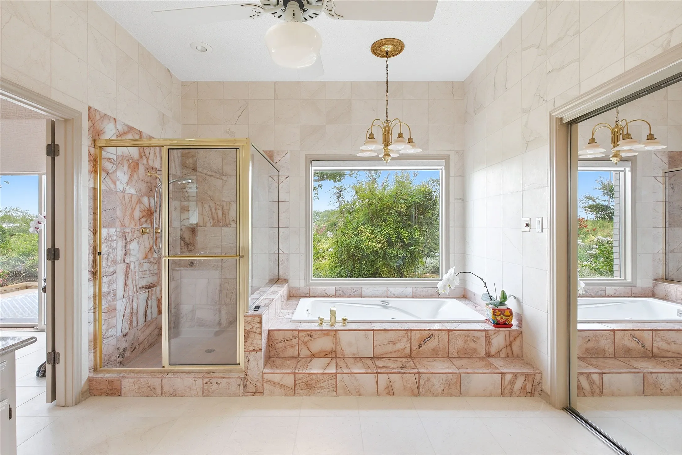 The primary bathroom has granite slab counter tops in bath, marble shower floors floor to ceiling, 10-foot-high natural limestone marble walls floor to ceiling.  A skylight provides natural lighting.  The closets are oversized walk-in with built-ins.
