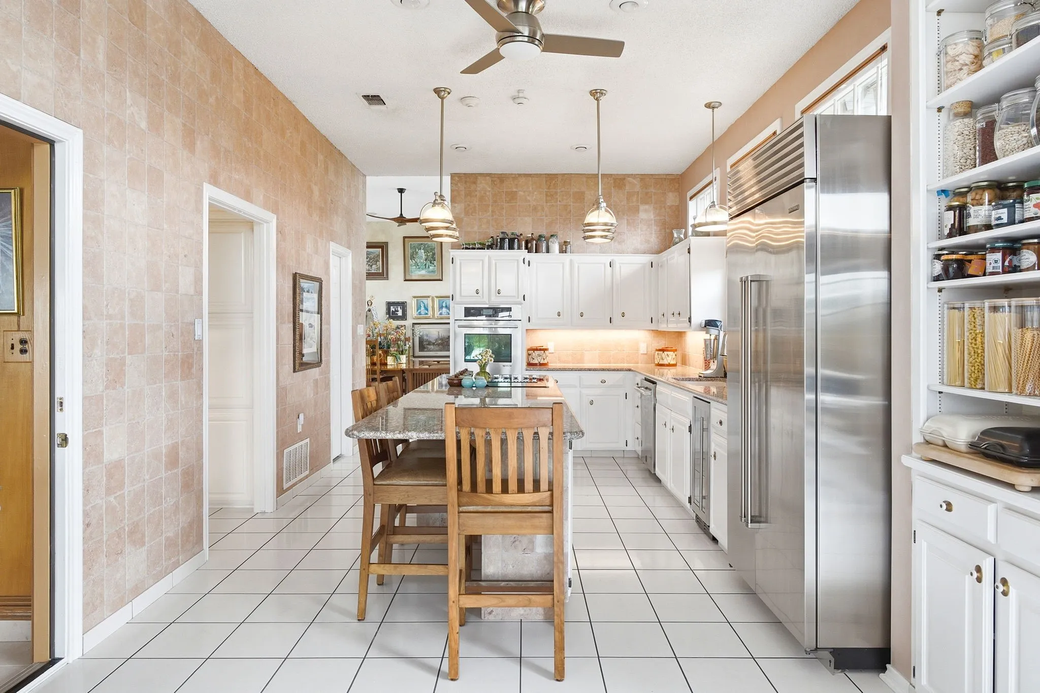 Enjoy the exceptional storage space of the custom cabinets.  The granite island provides extensive space for seating and serving.  The walls are 6" Italian tumbled marble tiles.