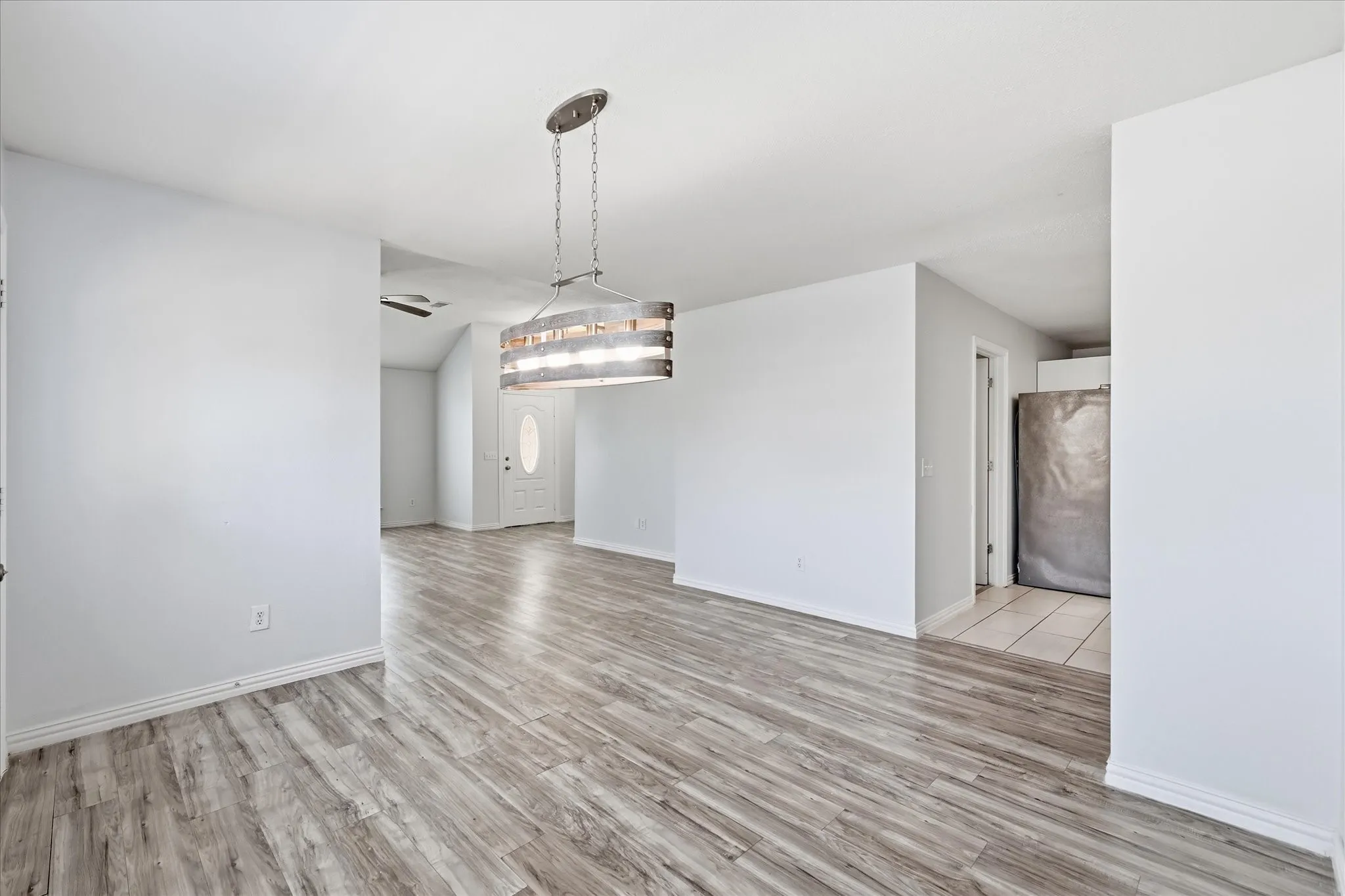 Dedicated dining area with luxury vinyl plank flooring, sized for a large gathering table.