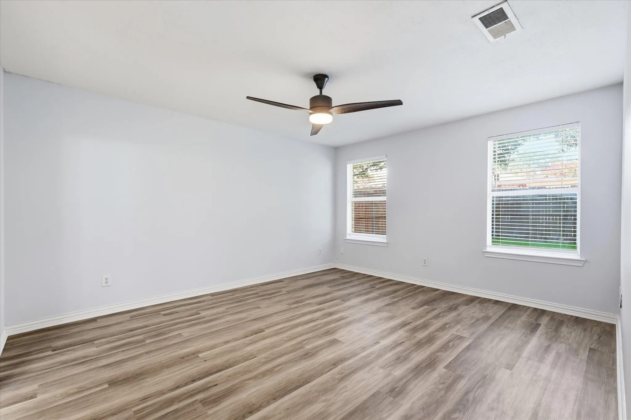 Bedroom: Additional spacious secondary bedroom featuring durable luxury vinyl plank flooring throughout.