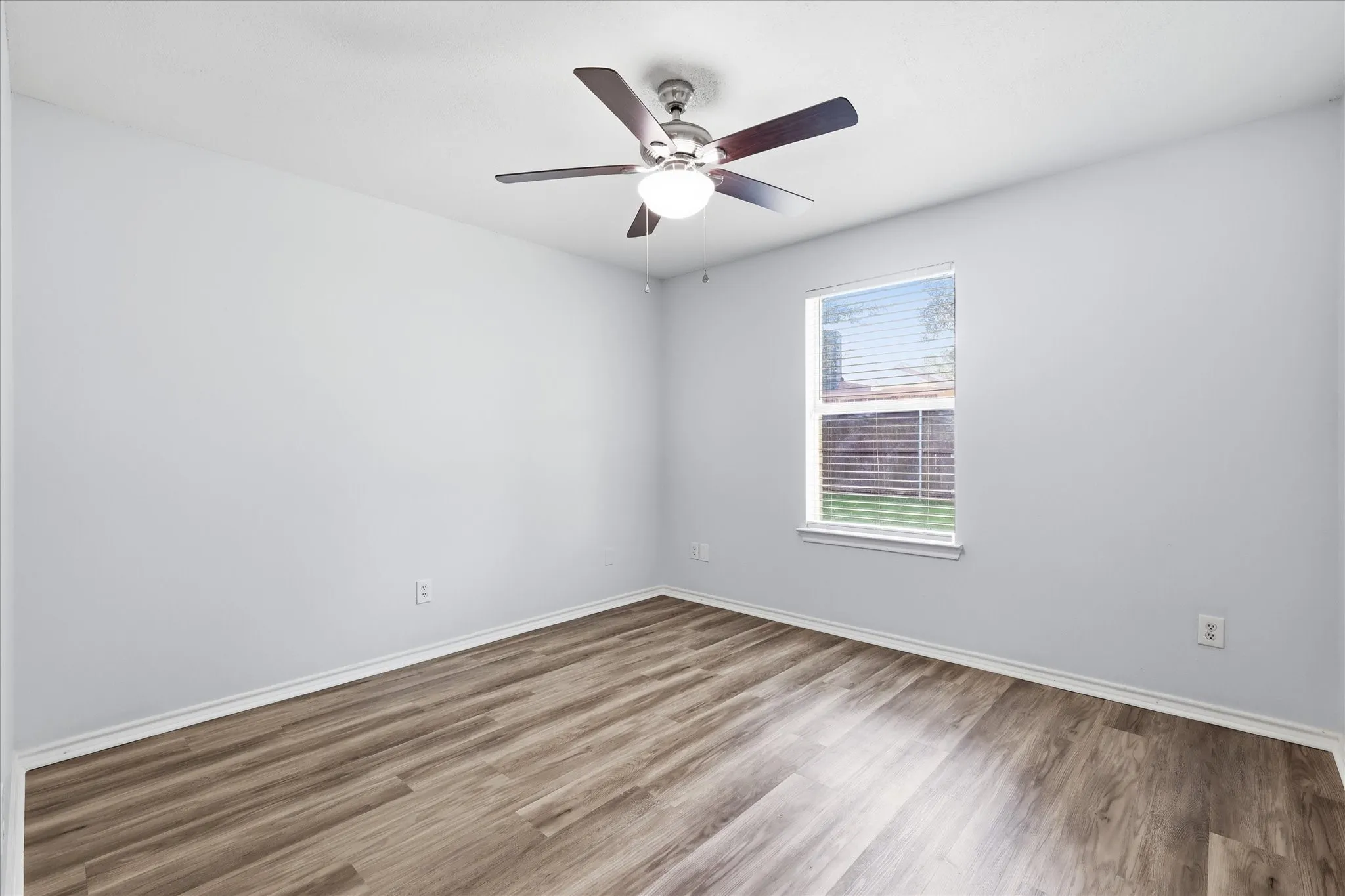  Good-sized secondary bedroom with luxury vinyl plank flooring, ideal for a bedroom or home office.