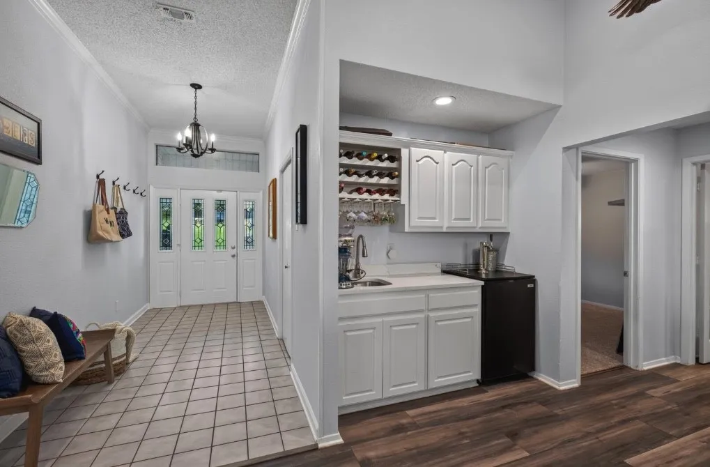 Entry way, and built in wine bar with sink, and beverage fridge.