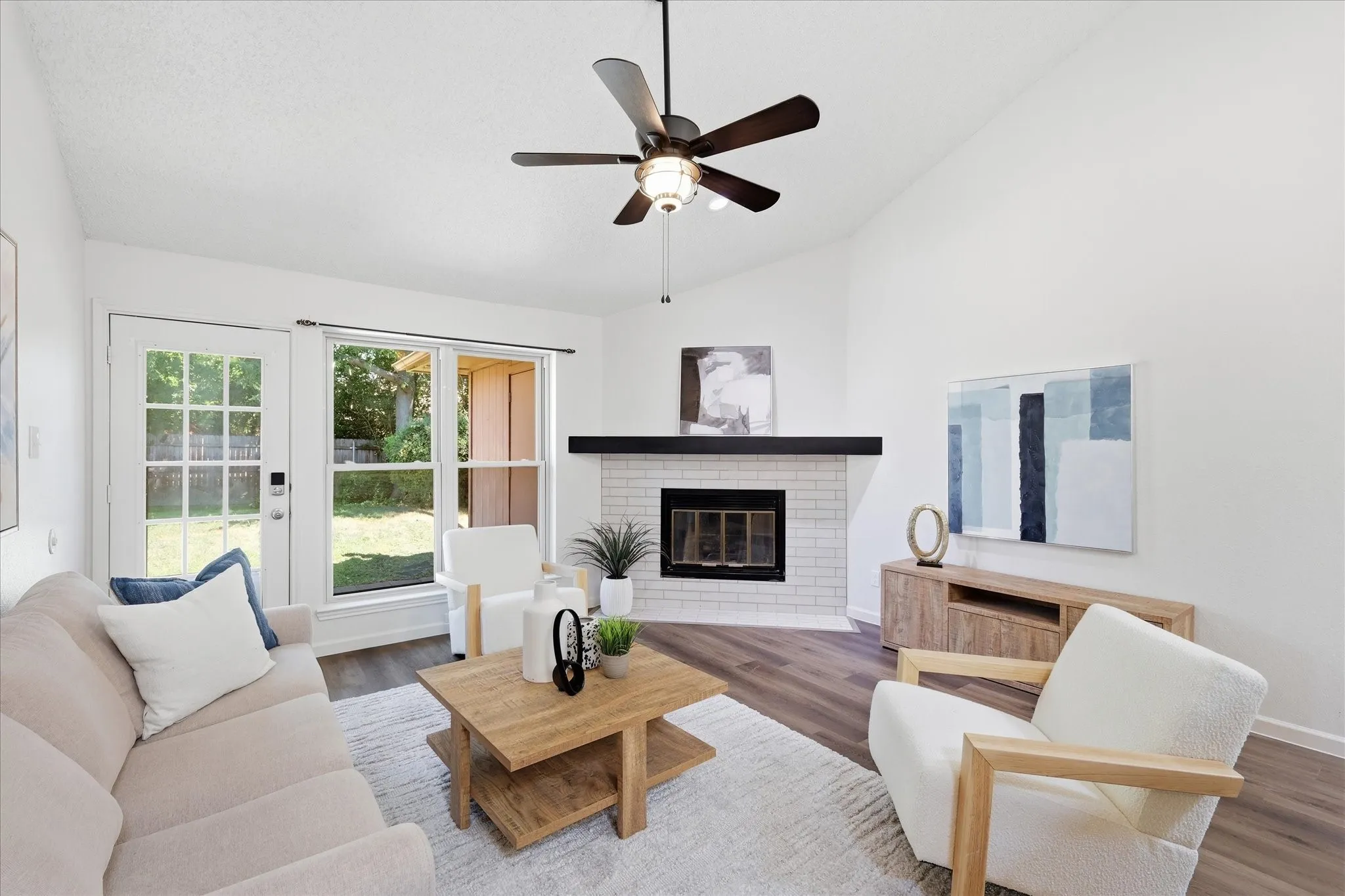 Sunny living room with luxury vinyl plank floors, fireplace and ceiling fan