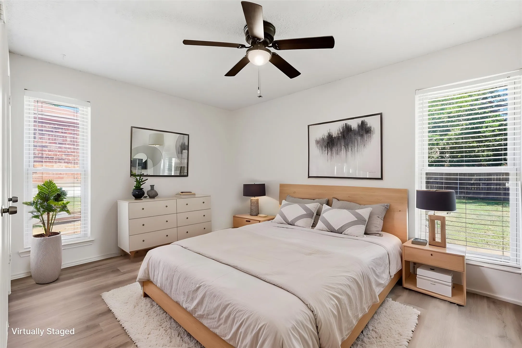 Virtually staged secondary bedroom featuring ceiling fan and luxury vinyl plank flooring