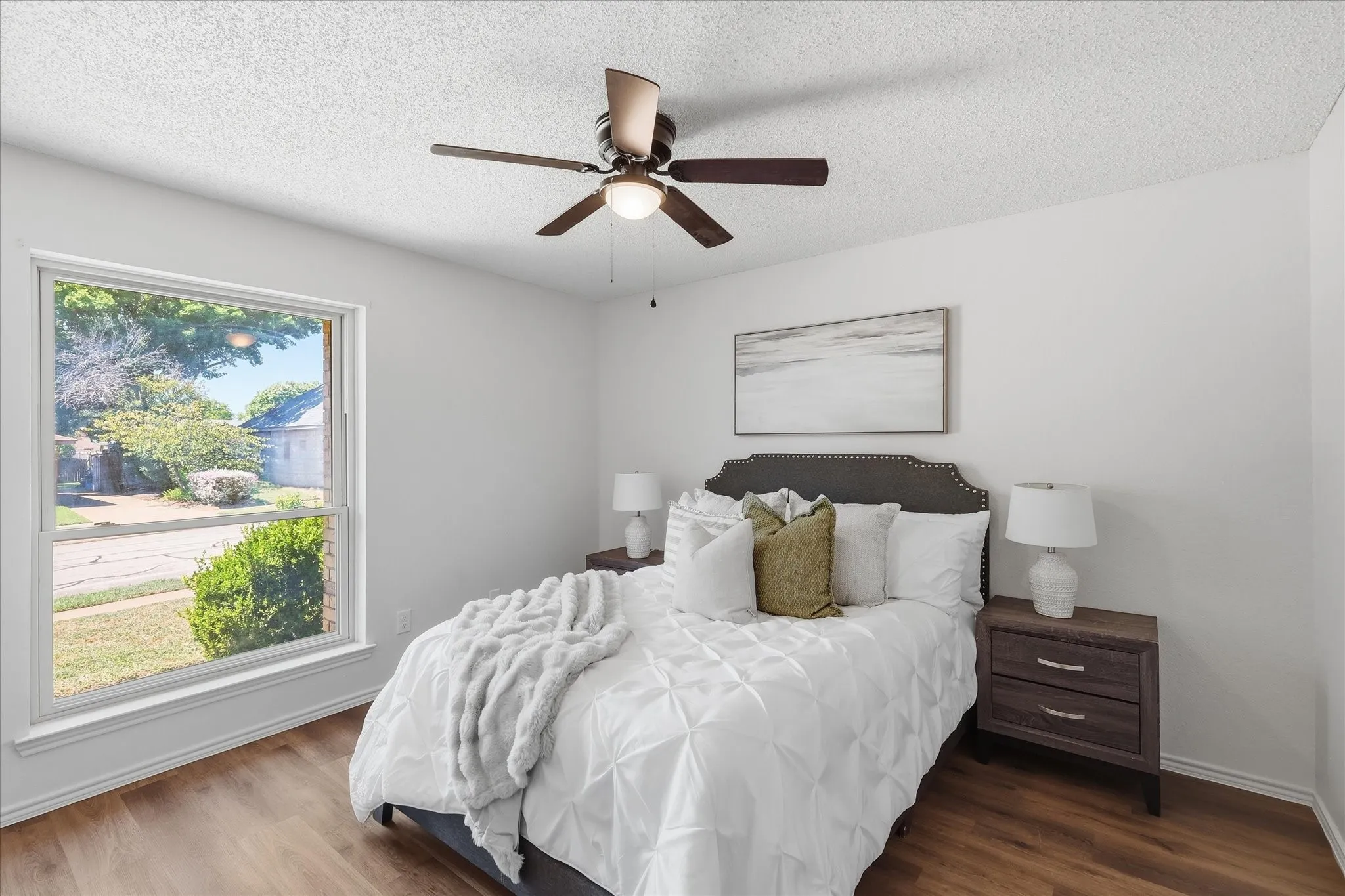 Primary bedroom with updated windows, ceiling fan and luxury vinyl plank floors