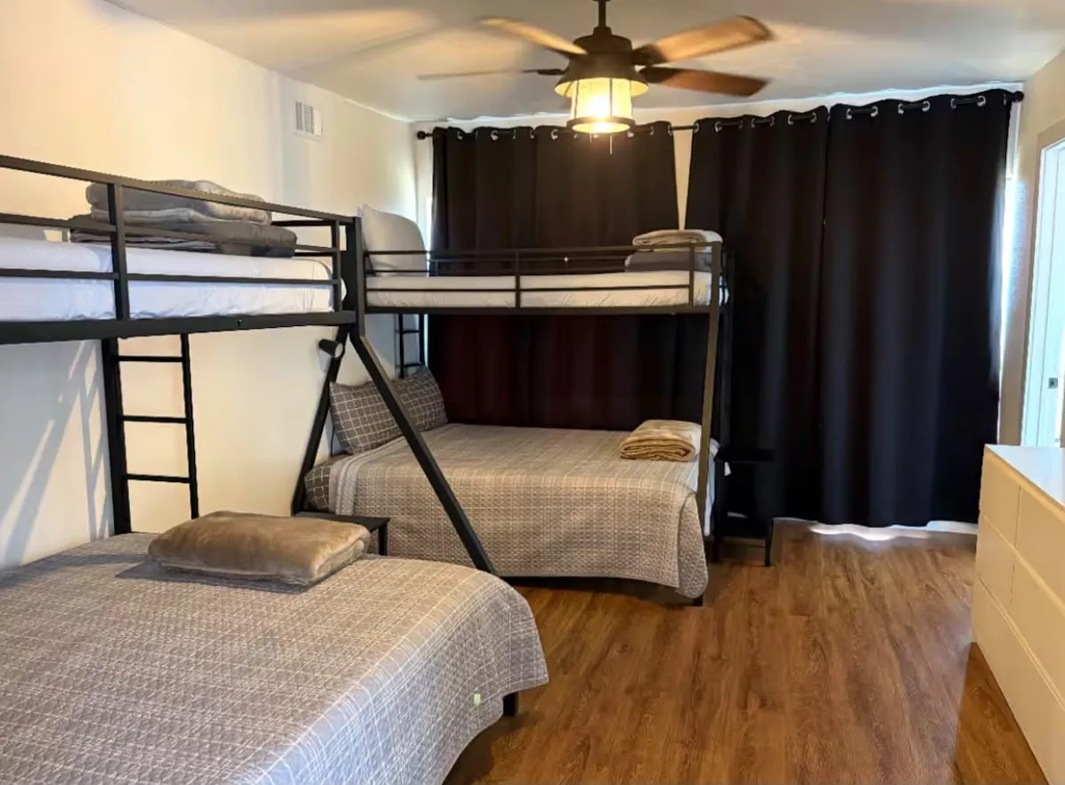 Spacious room with wood-finish flooring and white walls
