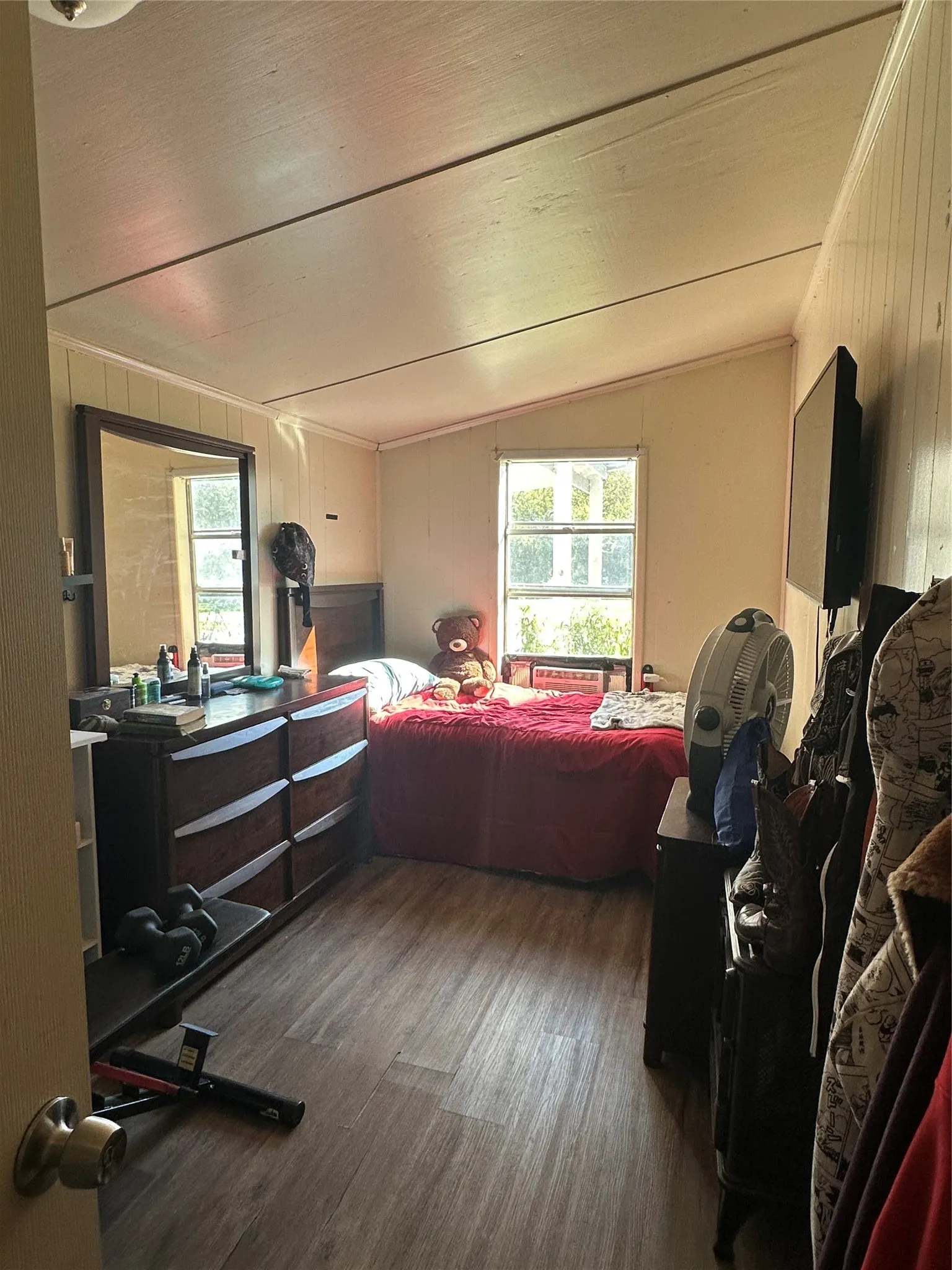 Room featuring wood-finish flooring, a single window, and sloped ceiling