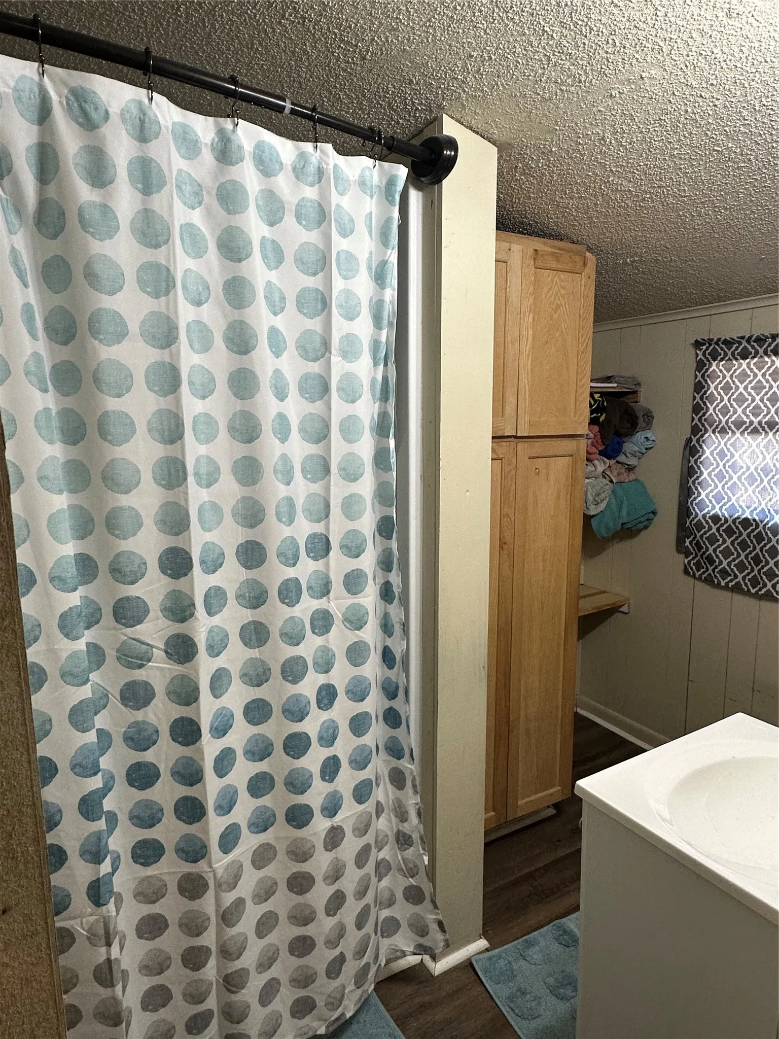 Bathroom featuring a built-in wood-finish cabinet and wood-finish flooring