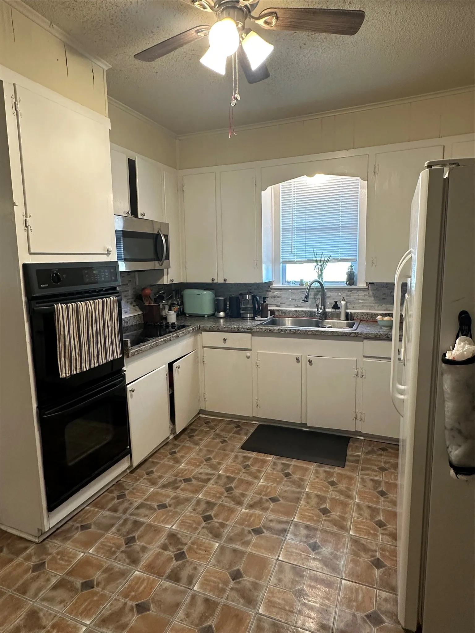 Kitchen featuring white cabinetry, patterned floor, and a double wall oven