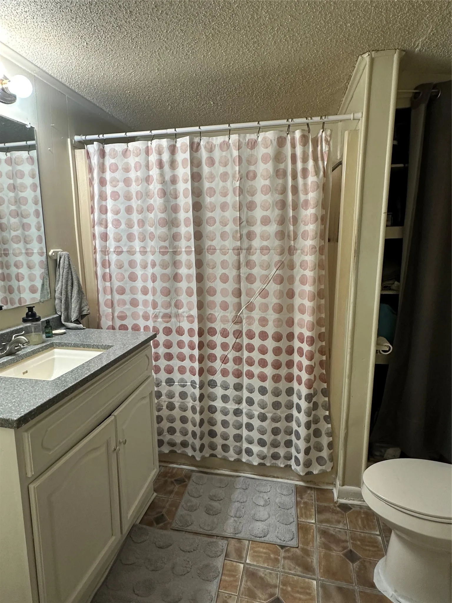 Bathroom featuring a white vanity with a granite countertop, an undermount sink, and a framed mirror