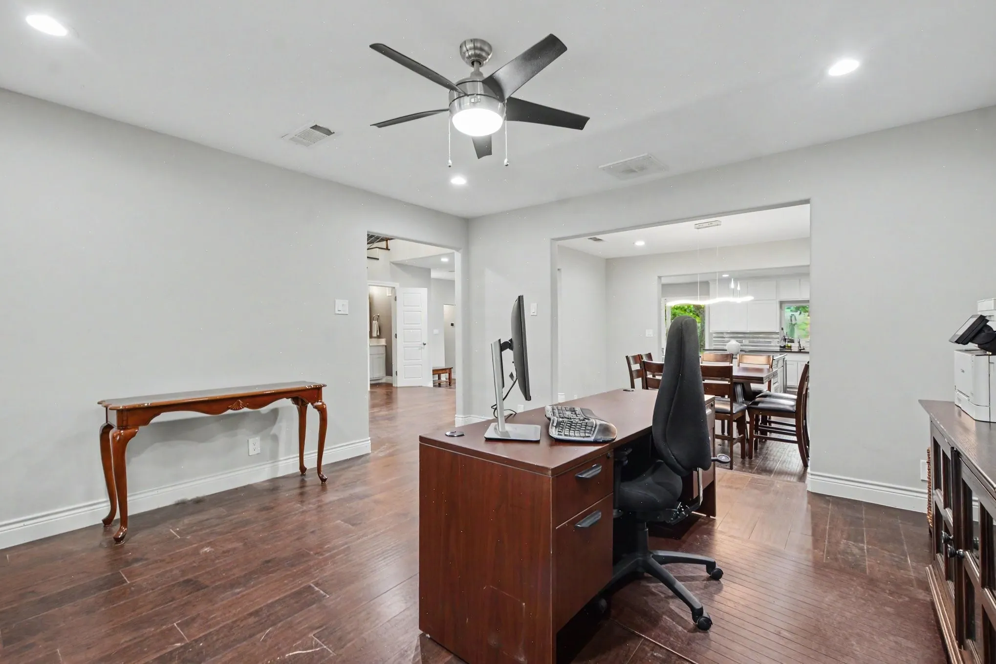 Spacious interior featuring wood-finish flooring, light gray wall paint, and recessed lighting