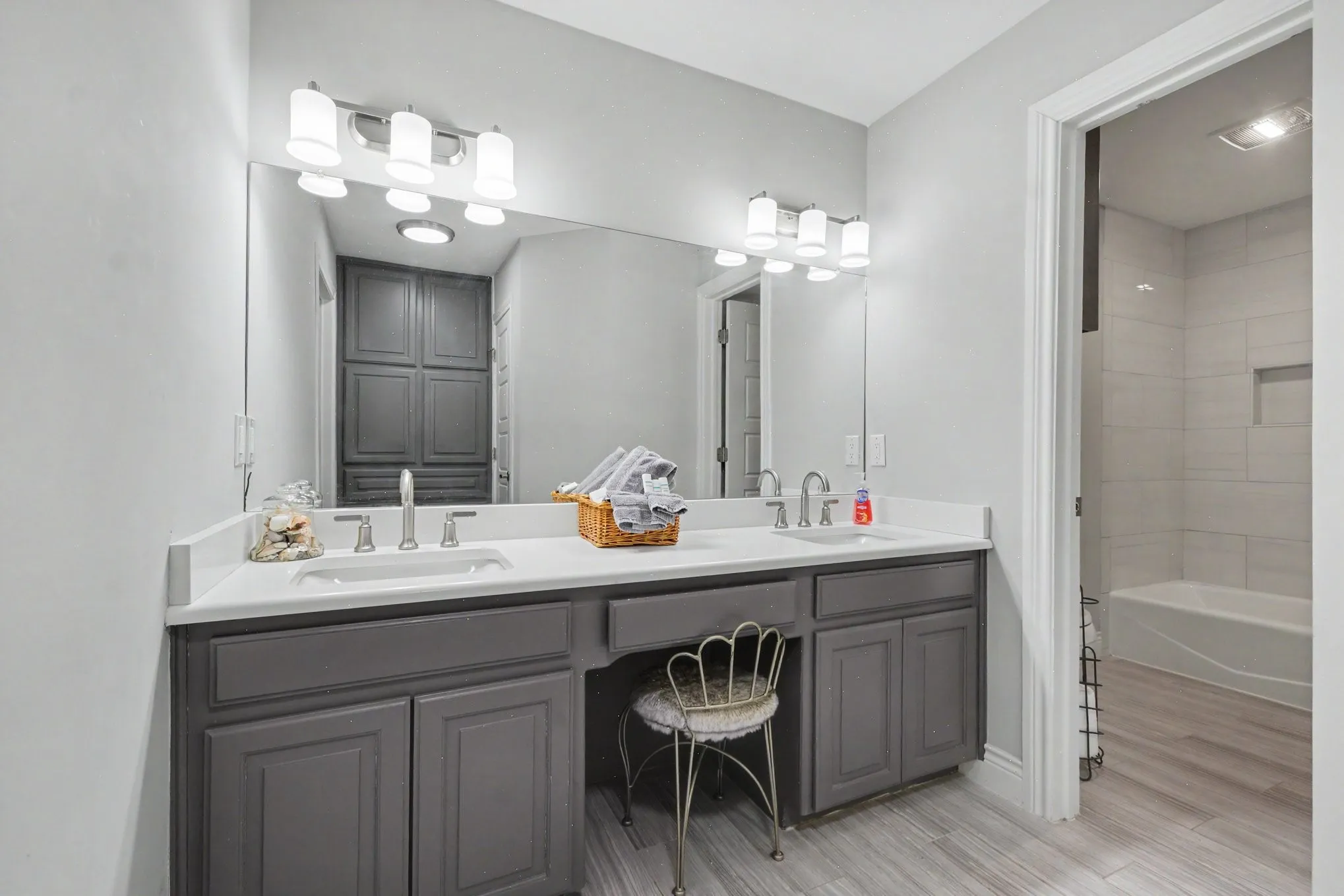 Dual vanity with gray cabinetry, white countertops, and integrated sinks