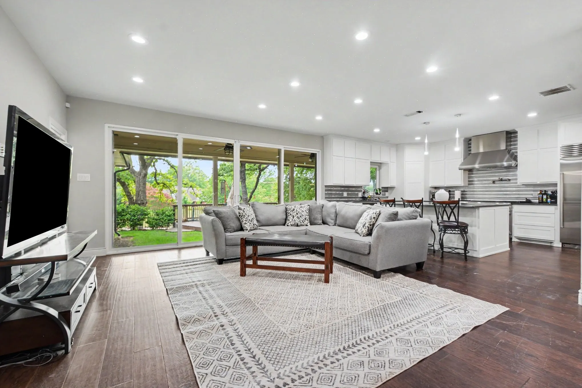 Open-concept living area featuring wood-finish flooring, recessed lighting, and a sliding glass door