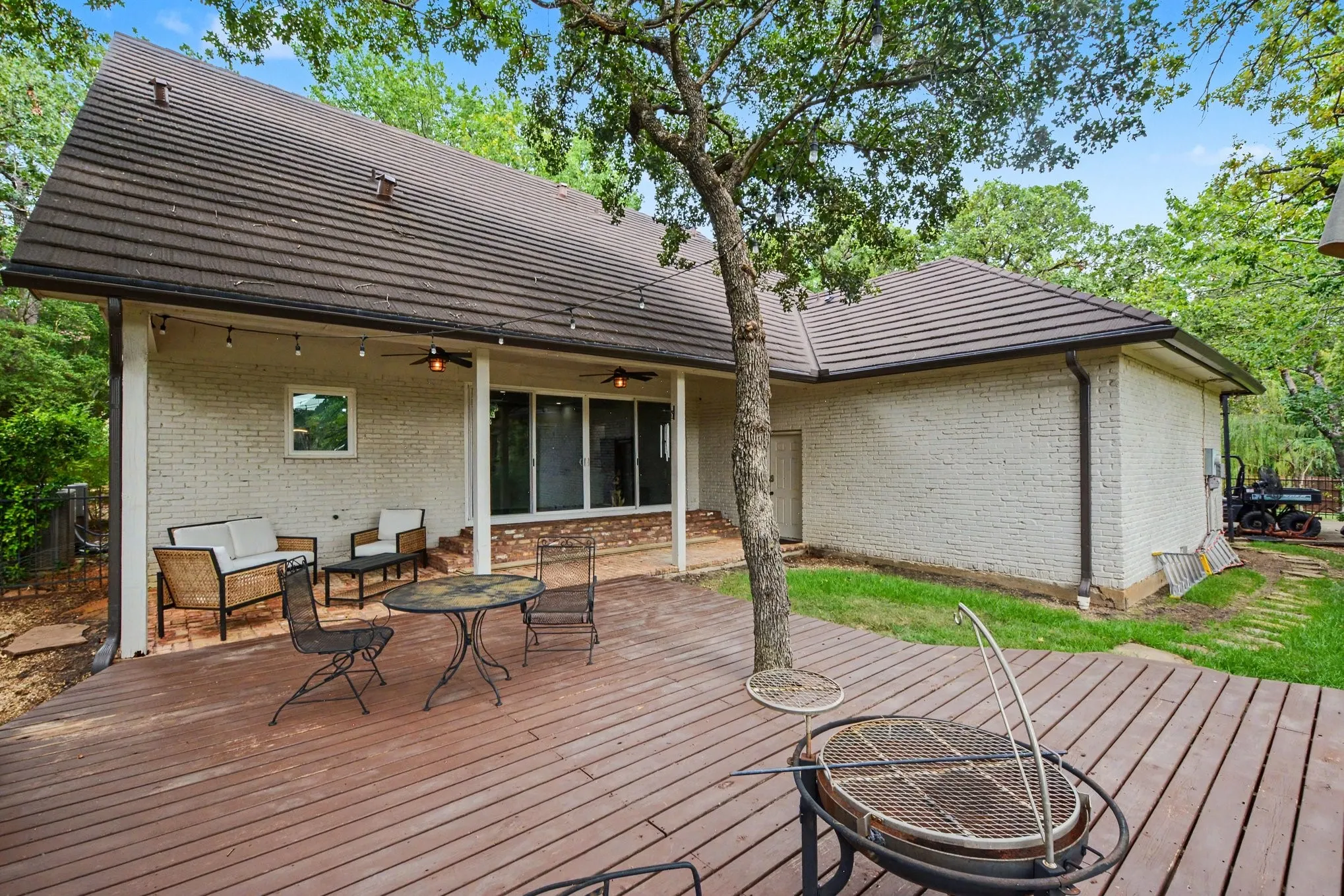 Expansive wood-finish deck with integrated tree, offering direct access to the rear of the property