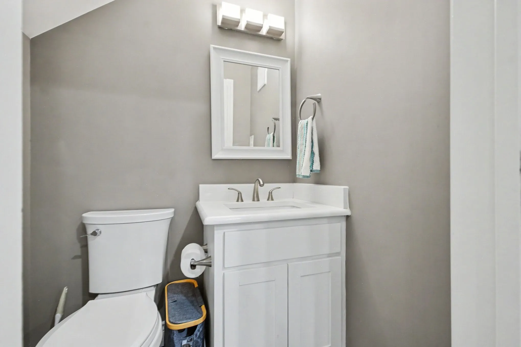 Modern vanity with white cabinetry, integrated sink, and brushed nickel faucet