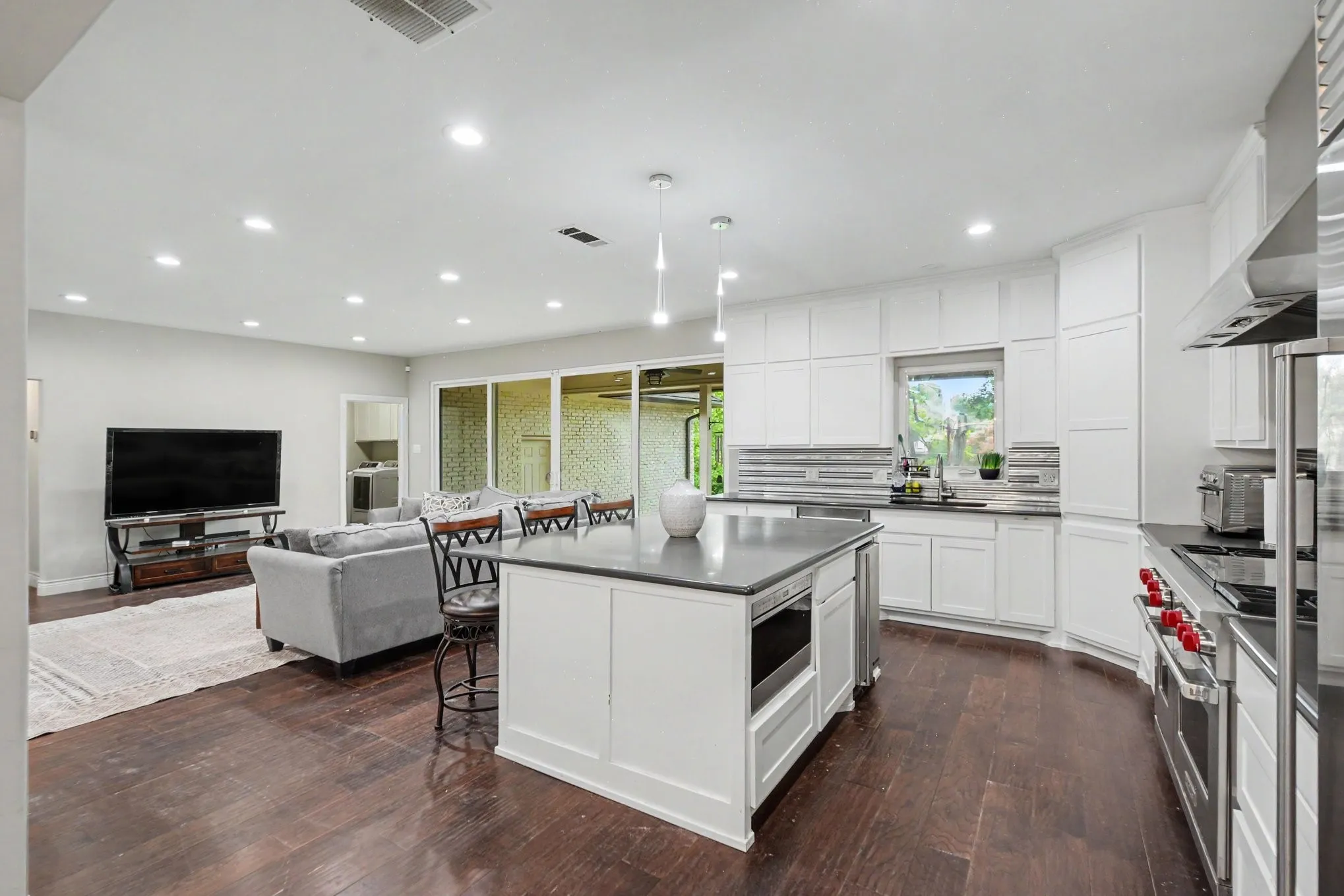Contemporary kitchen featuring white cabinetry, dark countertops, and stainless steel appliances