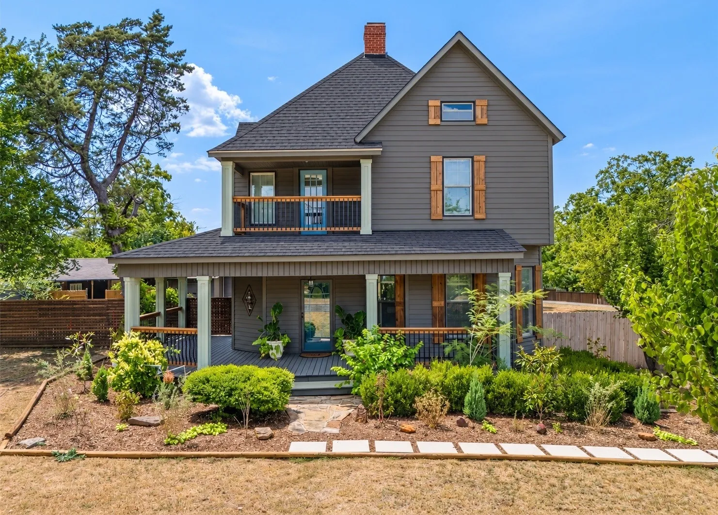 Two-story exterior with a porch, second-story balcony, horizontal siding, and a gabled roof