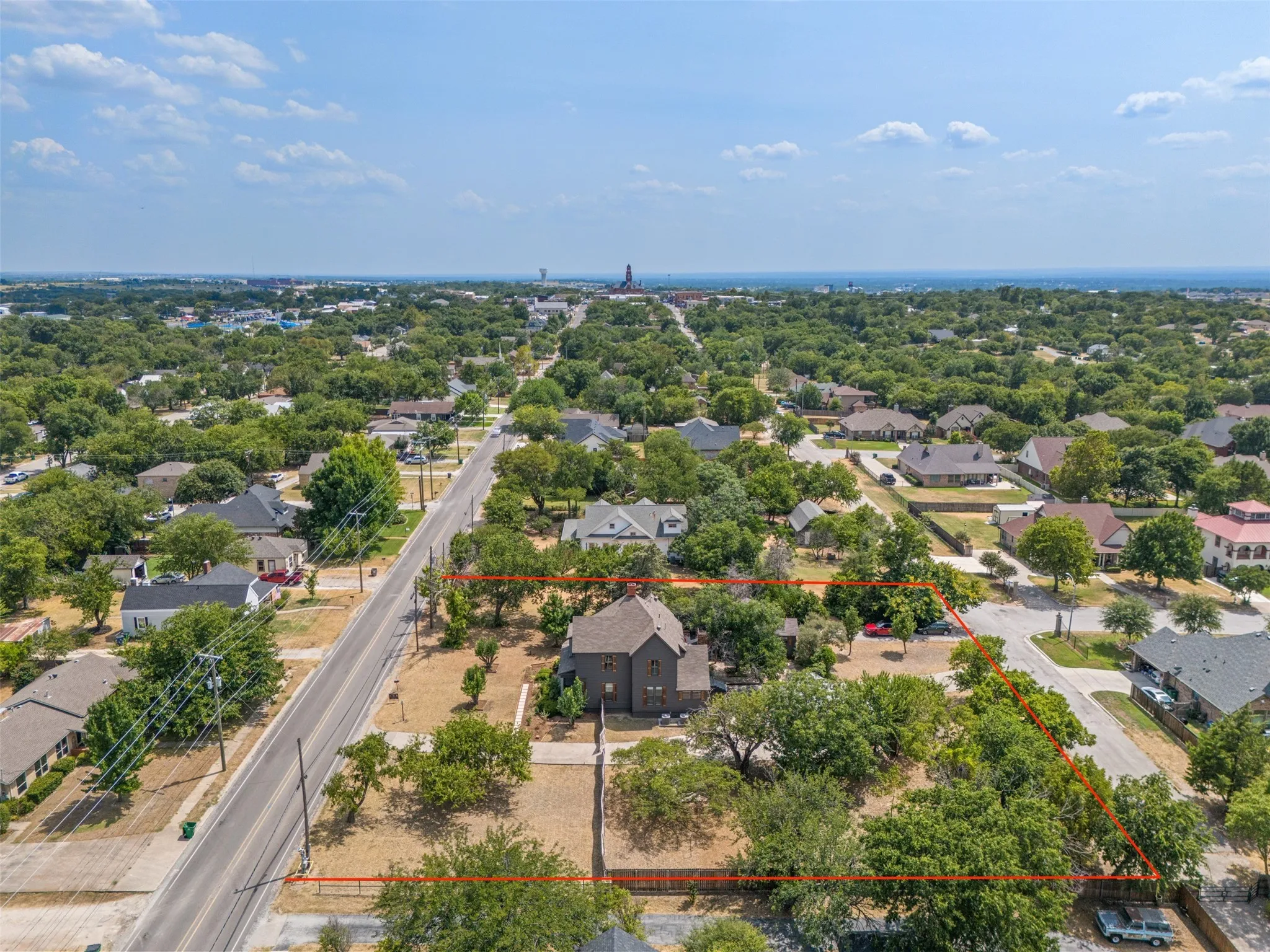 Aerial perspective showcasing the property's footprint, surrounded by mature trees and residential structures