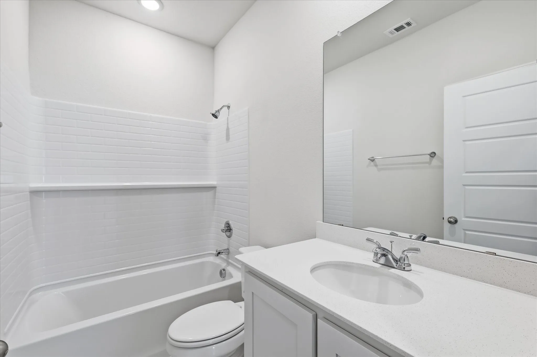 Guest bathroom with White subway tile shower surround with a built-in shelf, chrome fixtures, and recessed lighting
