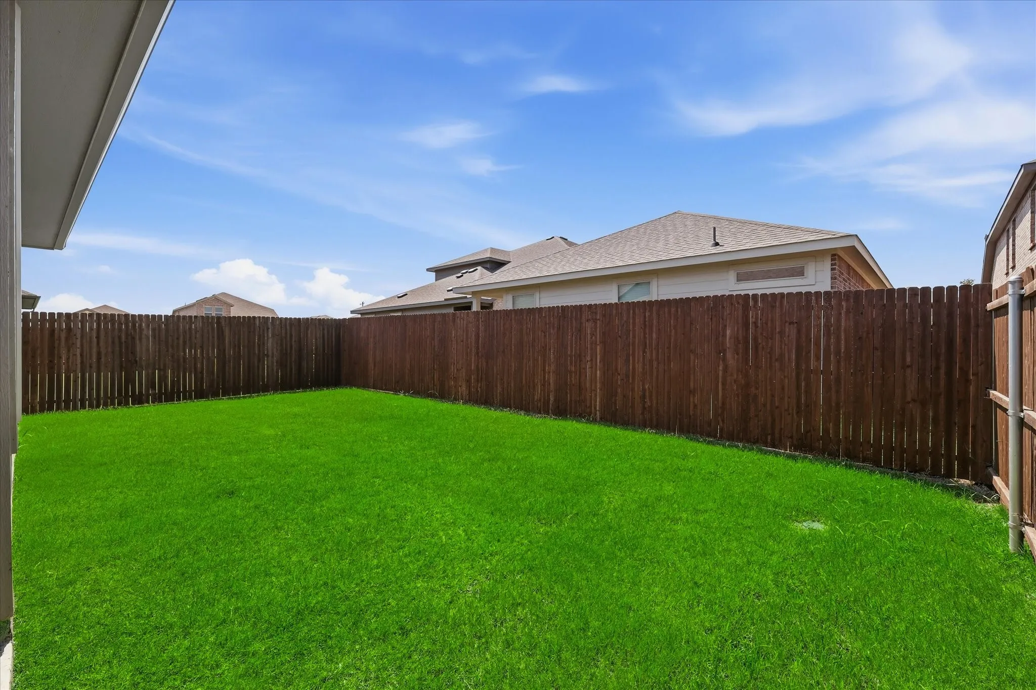 Fenced backyard with Grass covering.