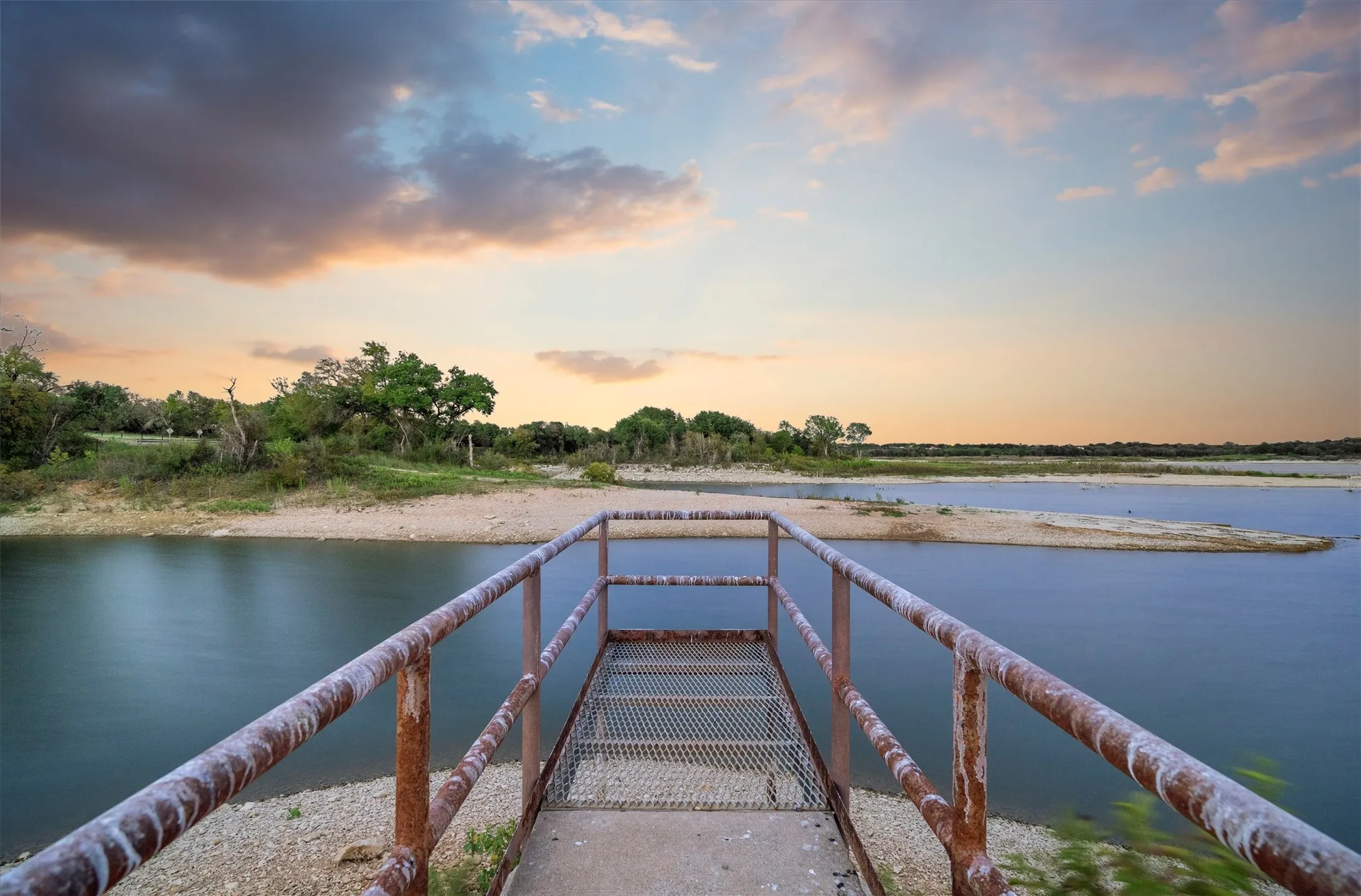 Waterfront access via a metal walkway extending over the tranquil water