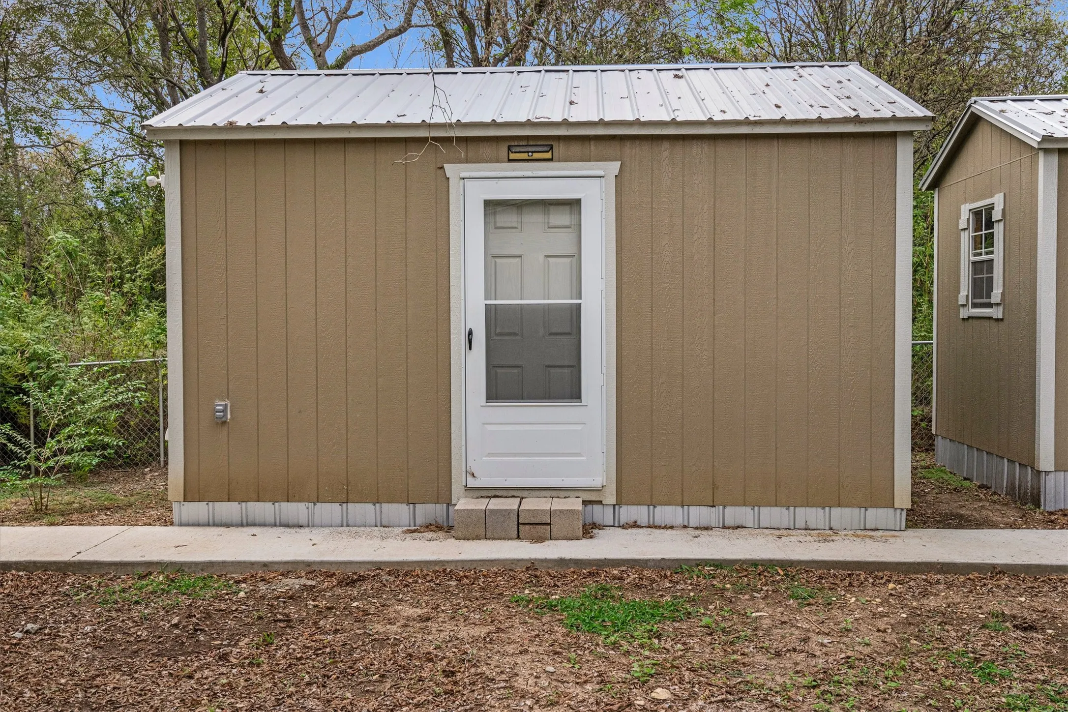 Freestanding structure featuring vertical panel siding and a metal roof