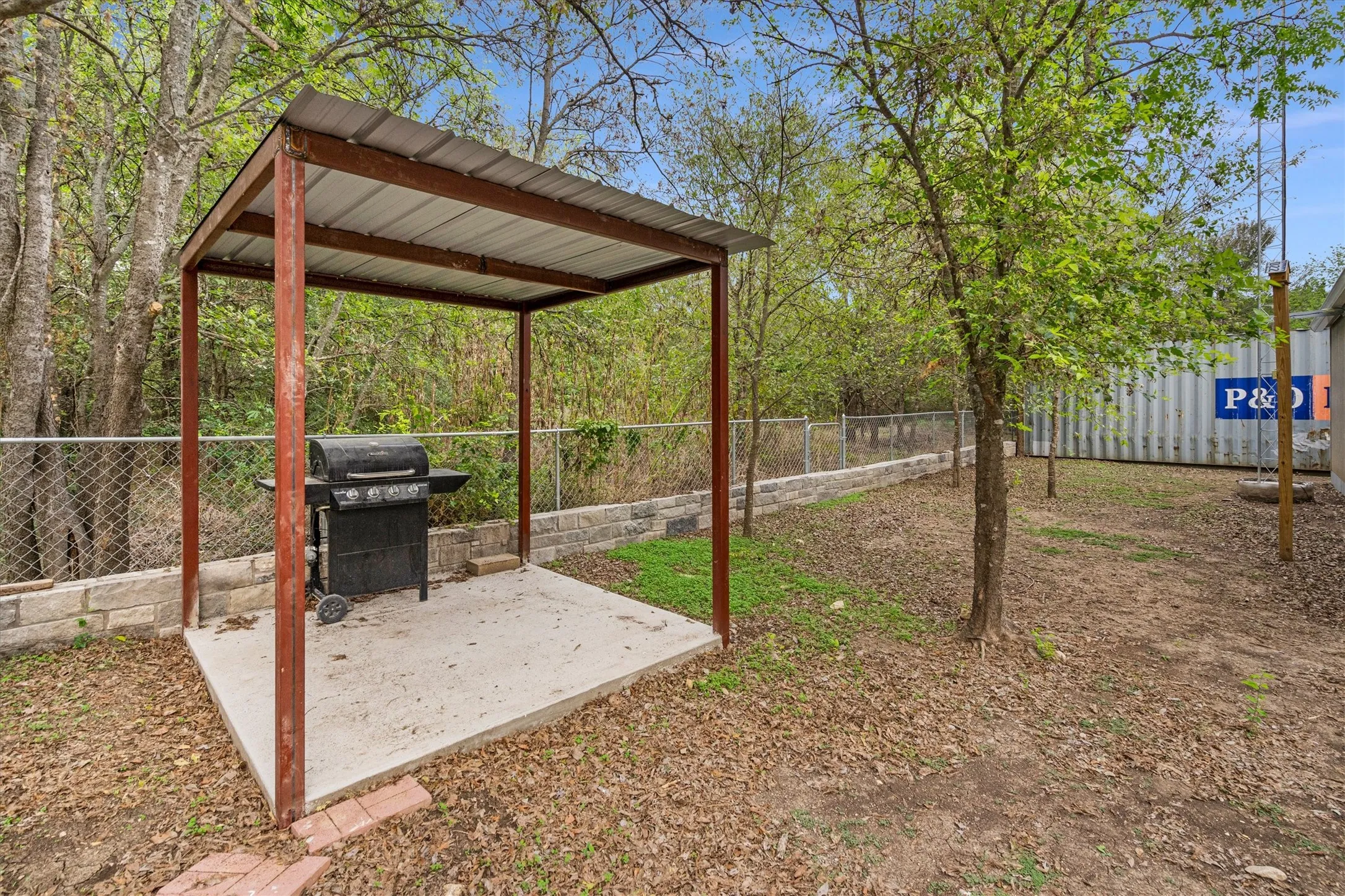 Outdoor covered patio space featuring a concrete pad and metal roof structure