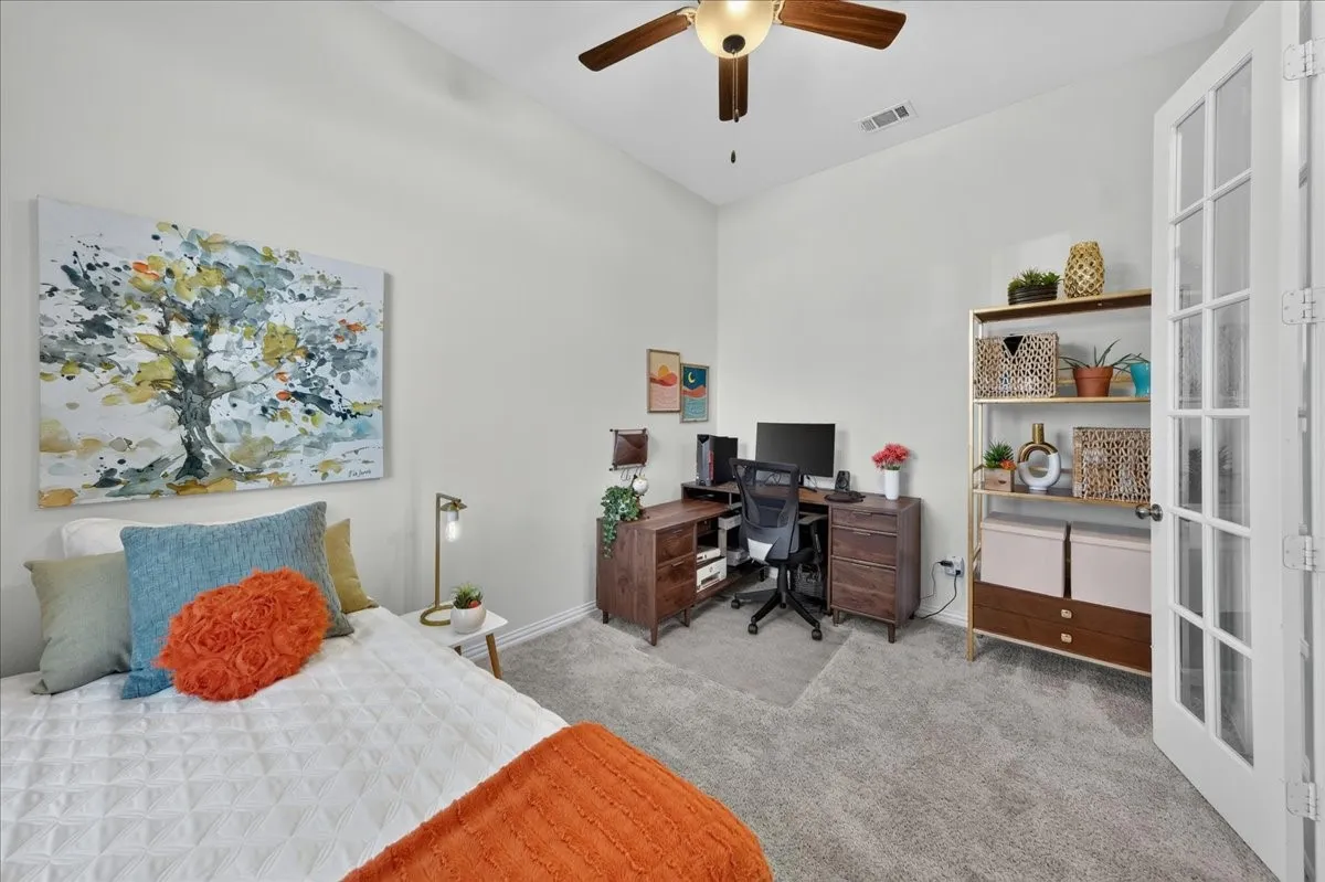 Vaulted ceiling with a ceiling fan, light gray carpet, and French doors