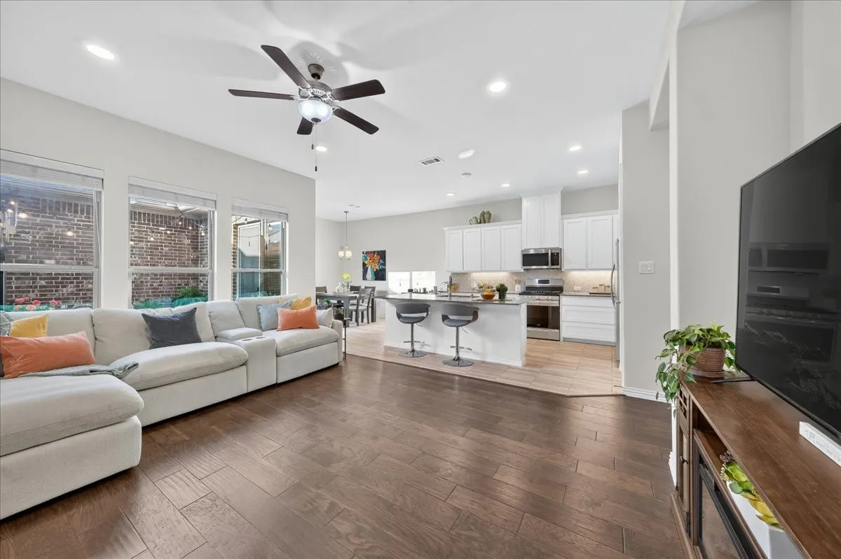 Open-concept living space featuring wood-finish flooring, recessed lighting, and a ceiling fan