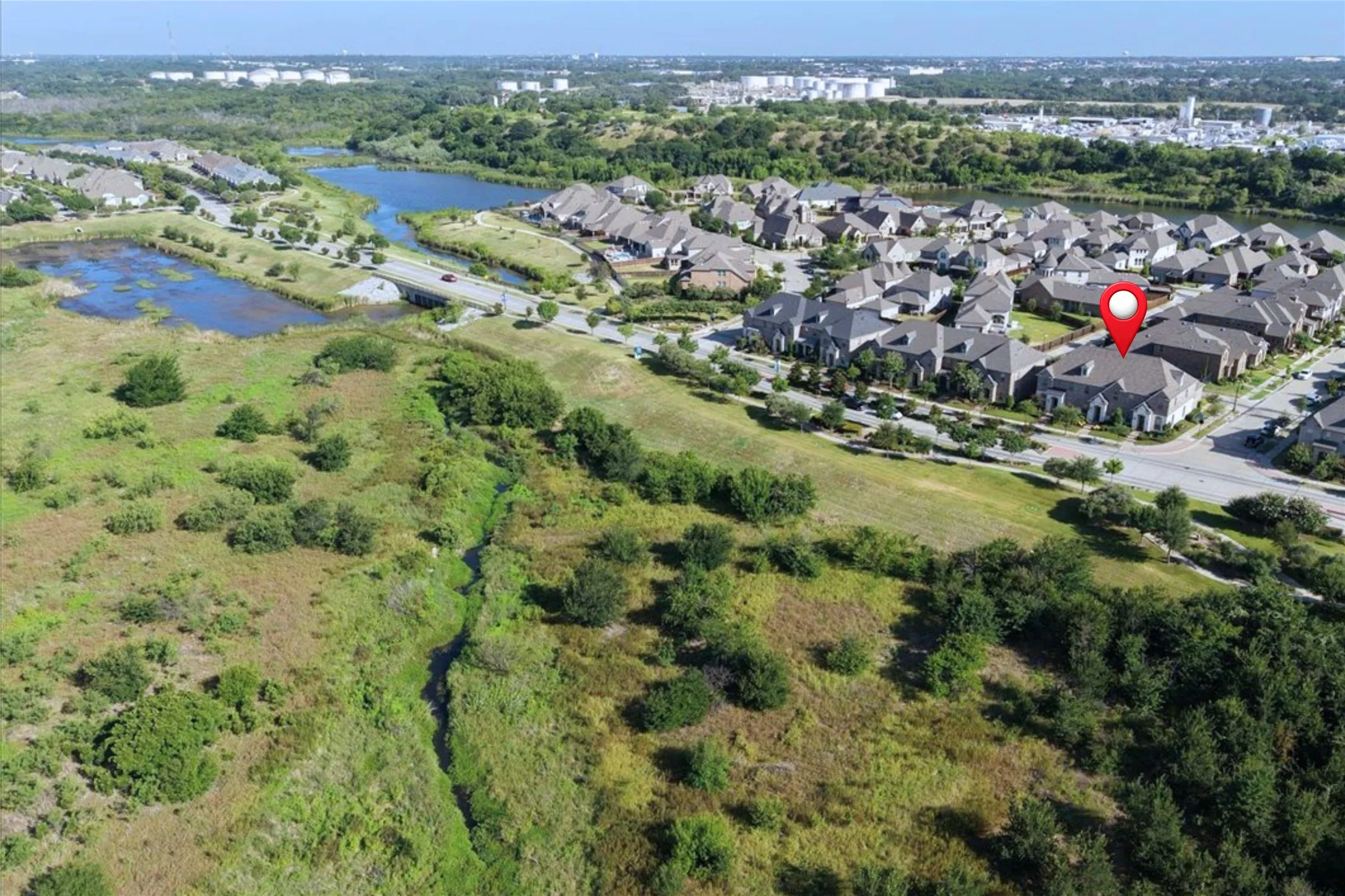Aerial perspective showcasing a residential community with numerous homes featuring dark roofs
