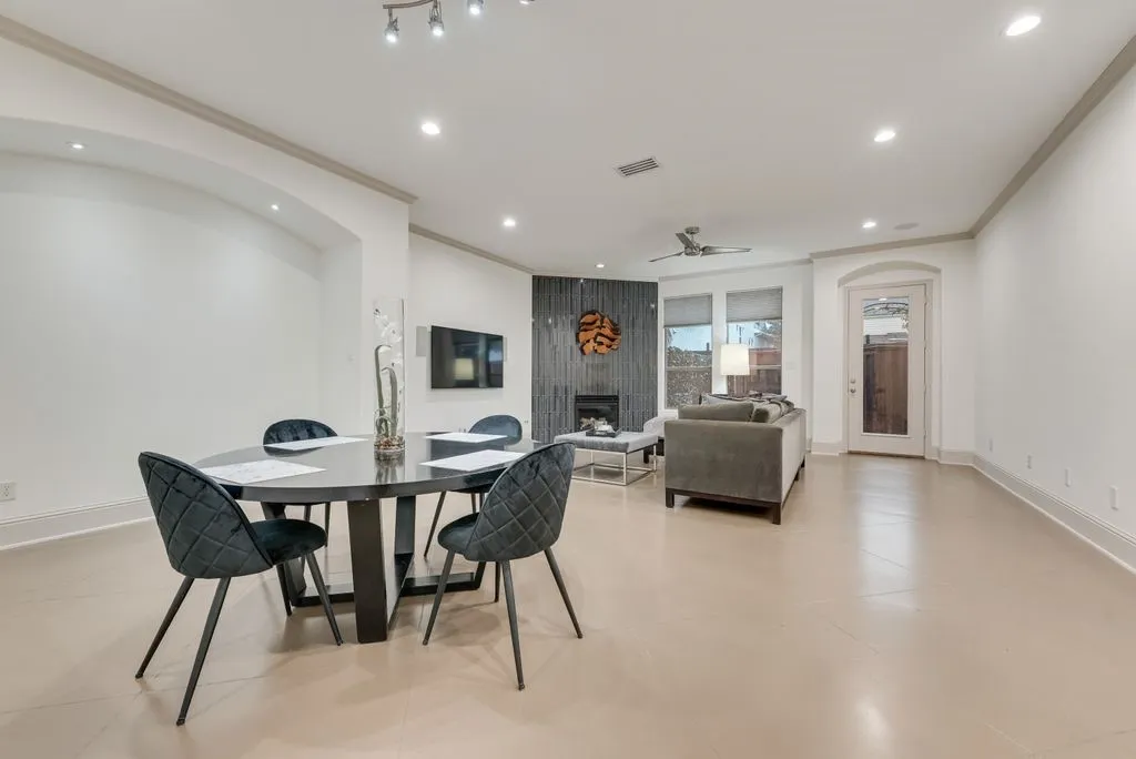 Open-concept living space featuring light-toned flooring, recessed lighting, and crown molding