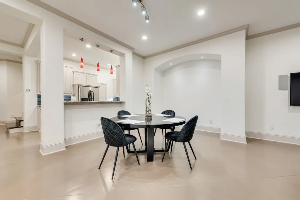 Open-concept living area featuring light-toned flooring, recessed lighting, and a built-in arched alcove with accent lighting