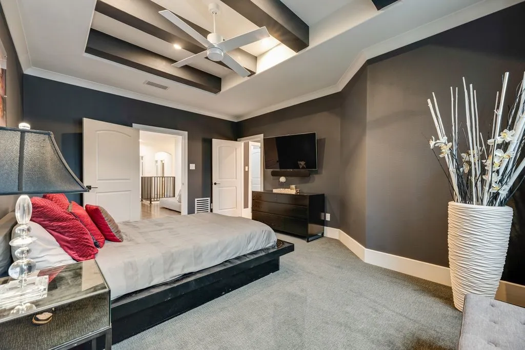 Bedroom featuring a tray ceiling with dark beam accents and recessed lighting