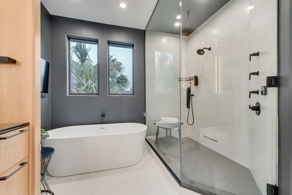 Contemporary bathroom featuring a freestanding soaking tub and a spacious glass-enclosed shower with matte black fixtures
